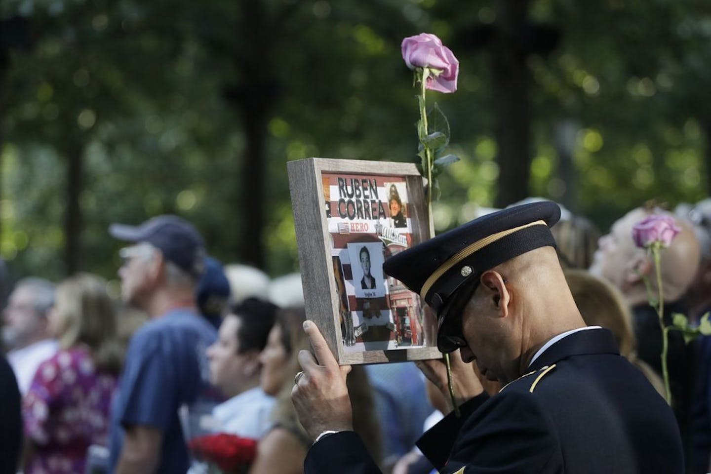 A man holds a photo of a victim during a ceremony marking the 18th anniversary of the attacks of Sept. 11, 2001 at the National September 11 Memorial, Wednesday, Sept. 11, 2019 in New York.