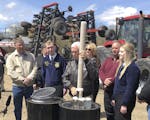 Vice President Mike Pence, center, holds a tube of soy beans as he tours the R & J Johnson Farms in Glyndon, Minn., Thursday, May 9, 2019, to talk abo