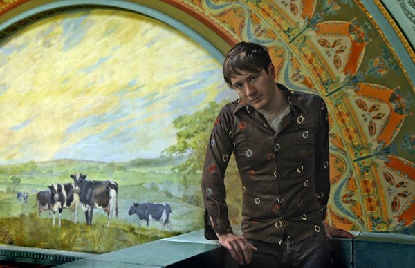 A meeting of Owatonna's most famous fixtures: Adam Young under the mural at the Louis Sullivan-designed National Farmer's Bank in his hometown.