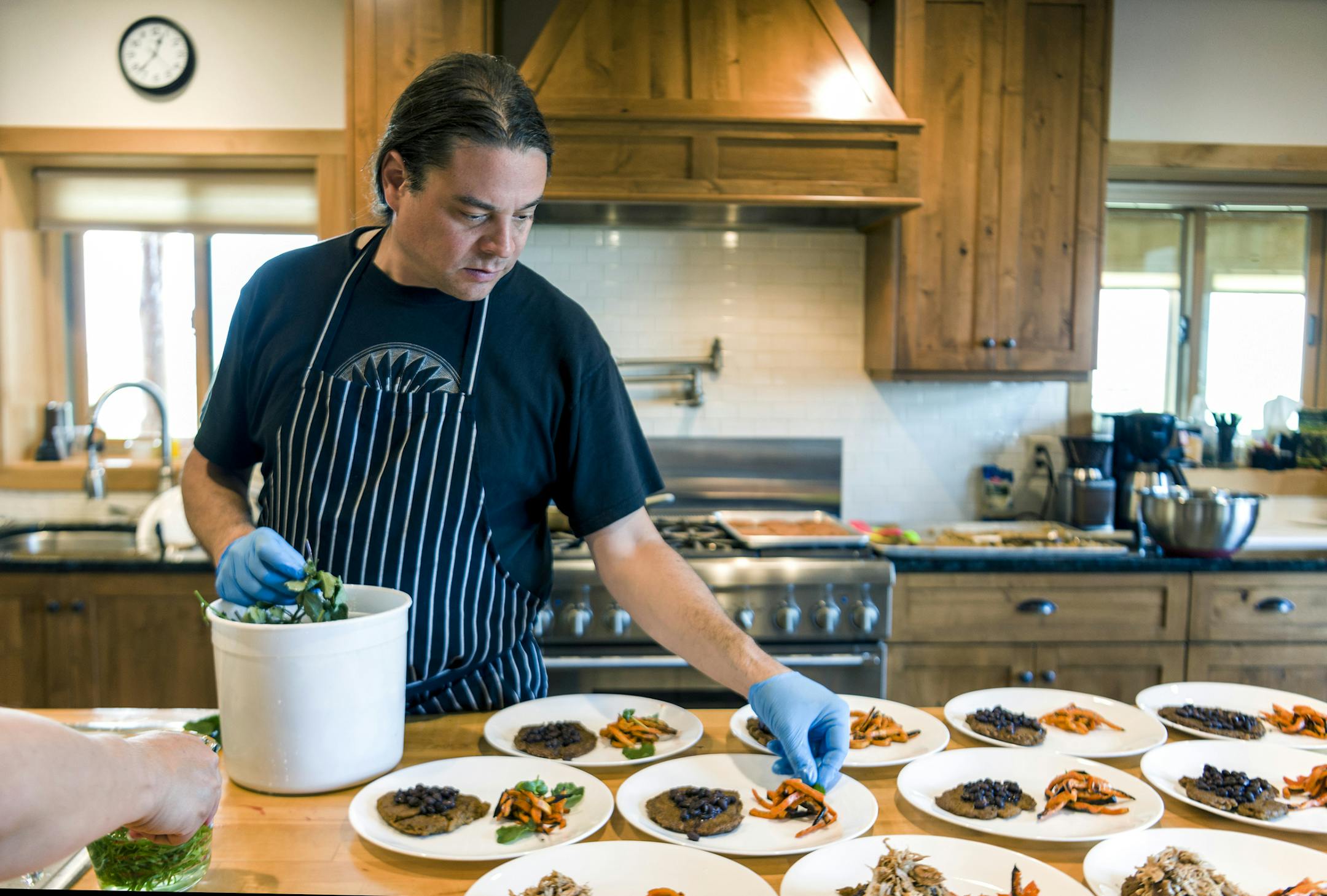 Chef Sean Sherman, who is Oglala Lakota and draws from the knowledge of the Lakota and Ojibwe tribes for his cooking, plating in the kitchen at Coteau des Prairies Lodge near Havana, N.D., July 19, 2016. Sherman's work is part of a slowly gathering movement that he and other cooks are calling “new Native American cuisine,” or “indigenous cuisine”-- an effort to revitalize native food cultures in contemporary kitchens. (Dan Koeck/The New York Times)
