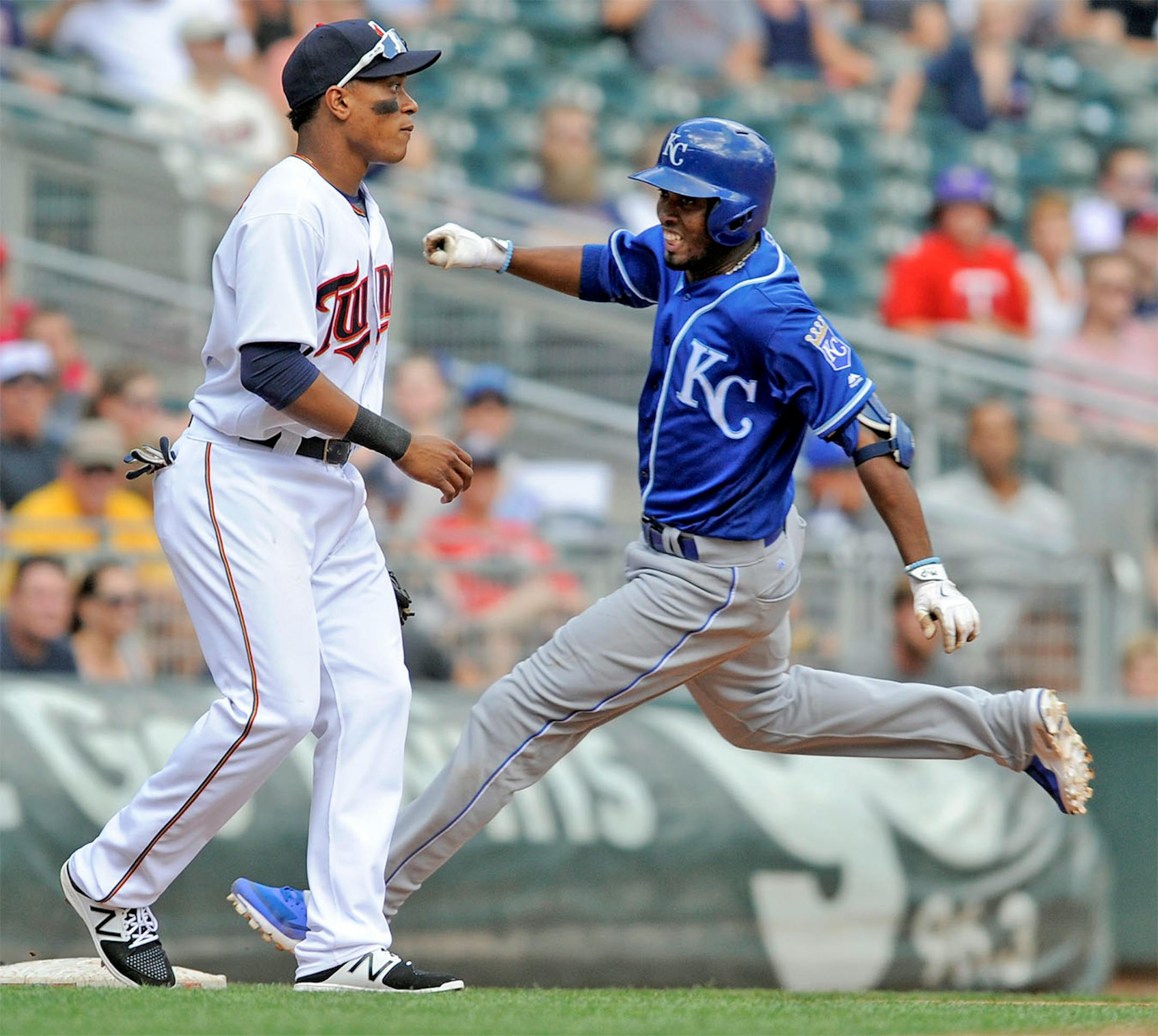Kansas City Royals' Alcides Escobar, right, goes into third base with a triple as Minnesota Twins third baseman Jorge Polanco, left, looks for the throw in the fourth inning of a baseball game, Sunday, Aug. 14, 2016, in Minneapoiis.