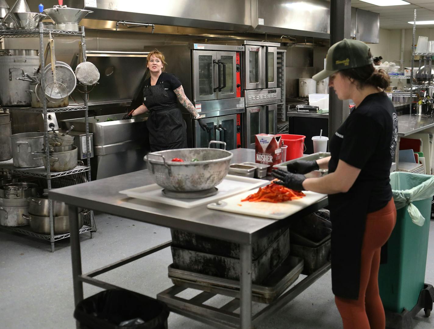 Arianna Baker-Kern, Chowgirls Killer Catering chef de cuisine, left, and Kate Kiernoziak, Chowgirls Killer Catering sous chef, prepare ingredients for cooked dishes that will be distributed by Loaves & Fishes to people in need Wednesday, March 18, 2020, in Minneapolis, MN. Much of the food came from Second Harvest Heartland and much of that was collected from local restaurants that are now closed.] DAVID JOLES &#x2022; david.joles@startribune.com Chowgirls is one of three restaurants that are pa