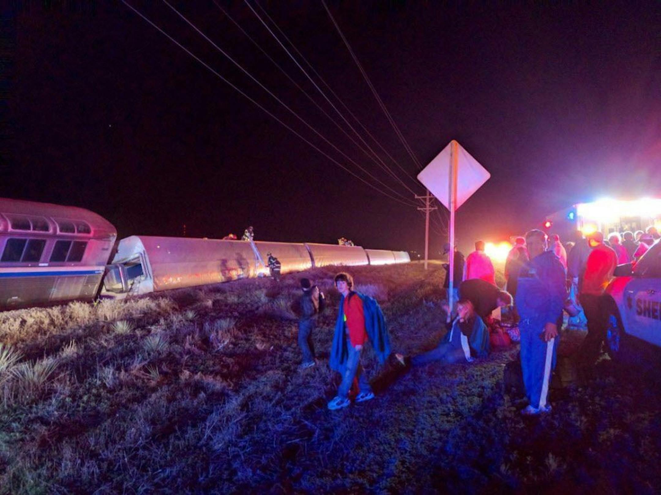 Passengers gather after a train derailed near Dodge City, Kan., Monday, March 14, 2016. An Amtrak statement says the train was traveling from Los Angeles to Chicago early Monday when it derailed just after midnight. (Daniel Szczerba via AP) MANDATORY CREDIT