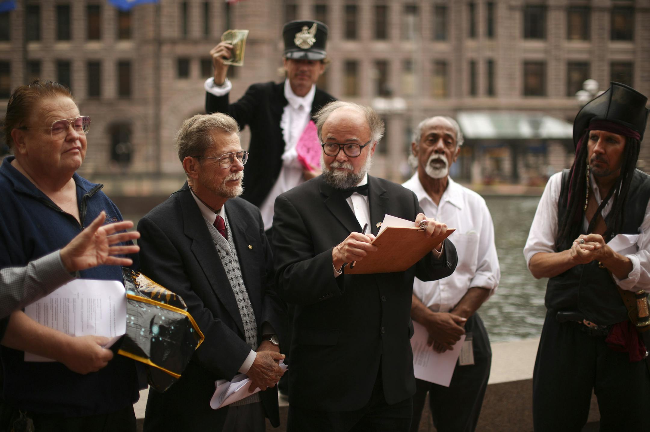 There are so many minor party candidates vying for the job of Minneapolis Mayor that several of them have banded together to form a "Mayoral Council" that meets weekly to advance their causes. The council met for the sixth time Wednesday afternoon, September 18, 2013 at Government Plaza across from City Hall in Minneapolis. The ten candidates who attended the Mayoral Council on Wednesday agreed to agree on several issues. Candidate Bob "Again" Carney Jr., with the clipboard, ran the meeting of t