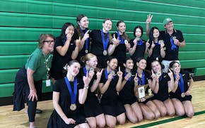 Edina's badminton team gathers with the trophy after winning the state championship Wednesday.