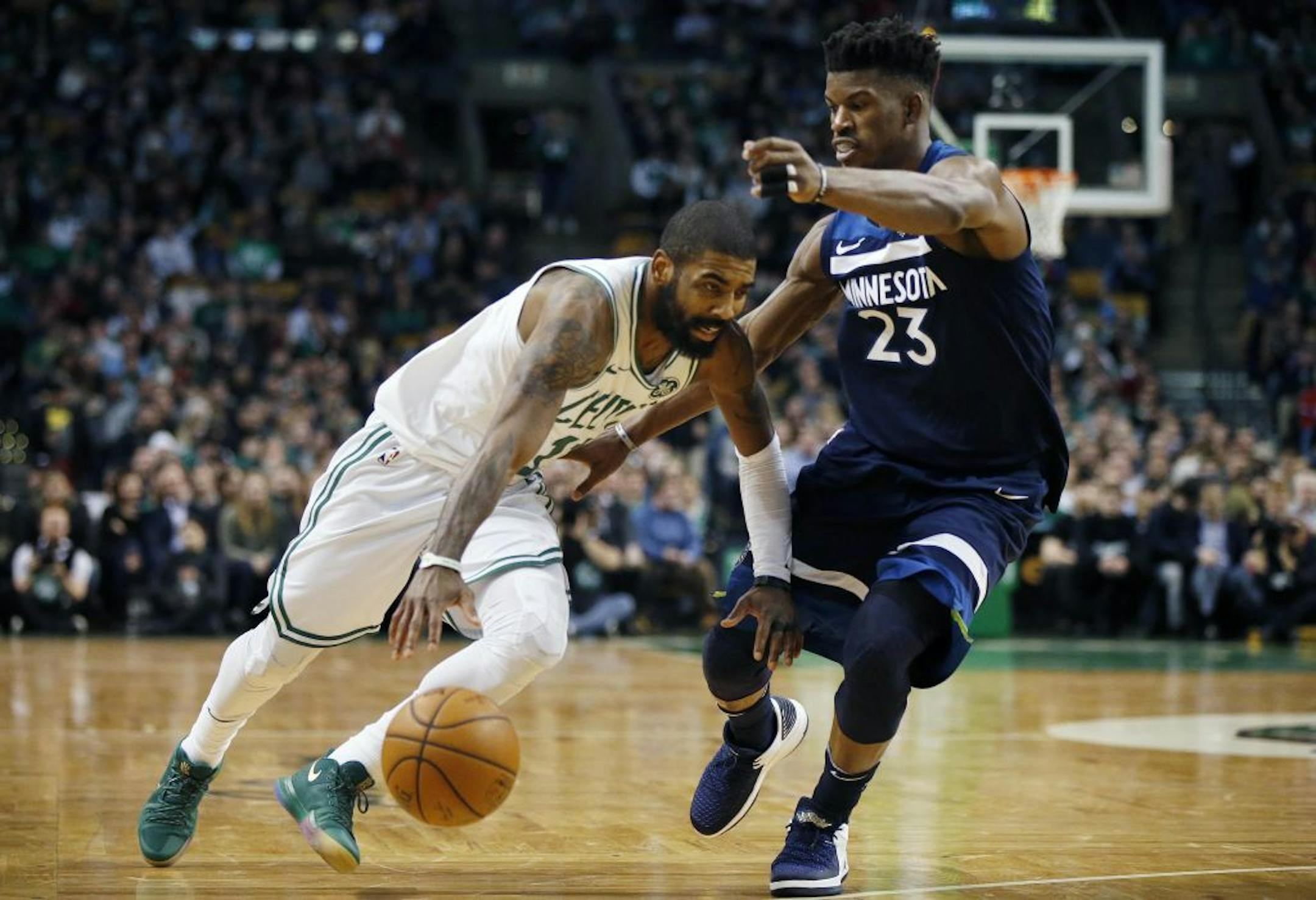 Boston Celtics' Kyrie Irving (11) drives past Minnesota Timberwolves' Jimmy Butler (23) during the second quarter of an NBA basketball in Boston, Friday, Jan. 5, 2018.