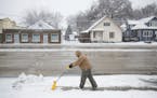 Mickey Robinson shovels snow and ice from the sidewalk Friday, Feb 24, 2017, in Omaha, Neb. A slow-moving storm has dropped nearly 2 feet of snow in w