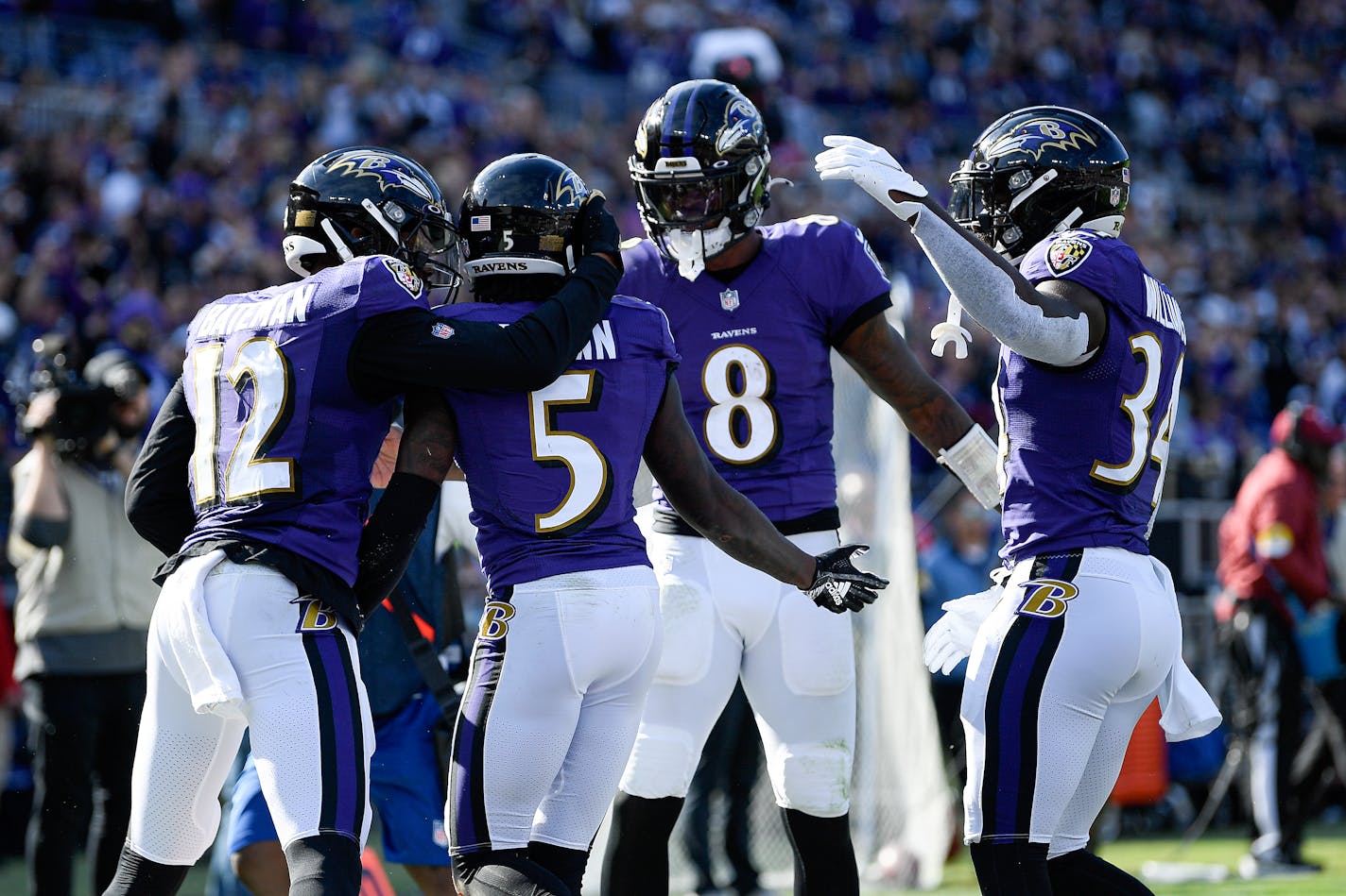 Baltimore Ravens quarterback Lamar Jackson (8) reacts after throwing a touchdown pass to wide receiver Marquise Brown (5) during the second half of an NFL football game against the Cincinnati Bengals, Sunday, Oct. 24, 2021, in Baltimore. Ravens' Rashod Bateman (12) and Ty'Son Williams (34) join in on the celebration. (AP Photo/Nick Wass)