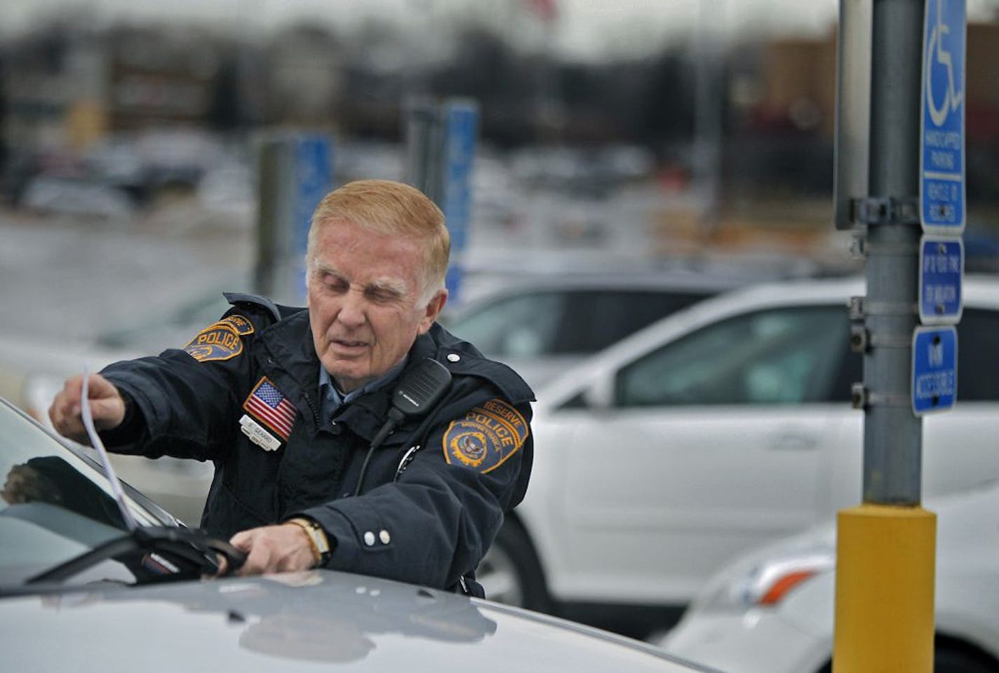 Billy Gerard put a warning on a vehicle where the handicapped sign was blocked during his routine shift at Ridgedale Center Mall, Thursday, January 24, 2013.