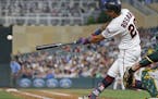 Minnesota Twins' Eddie Rosario hits an RBI single off Oakland Athletics pitcher Trevor Cahill during the fourth inning of a baseball game Thursday, Au