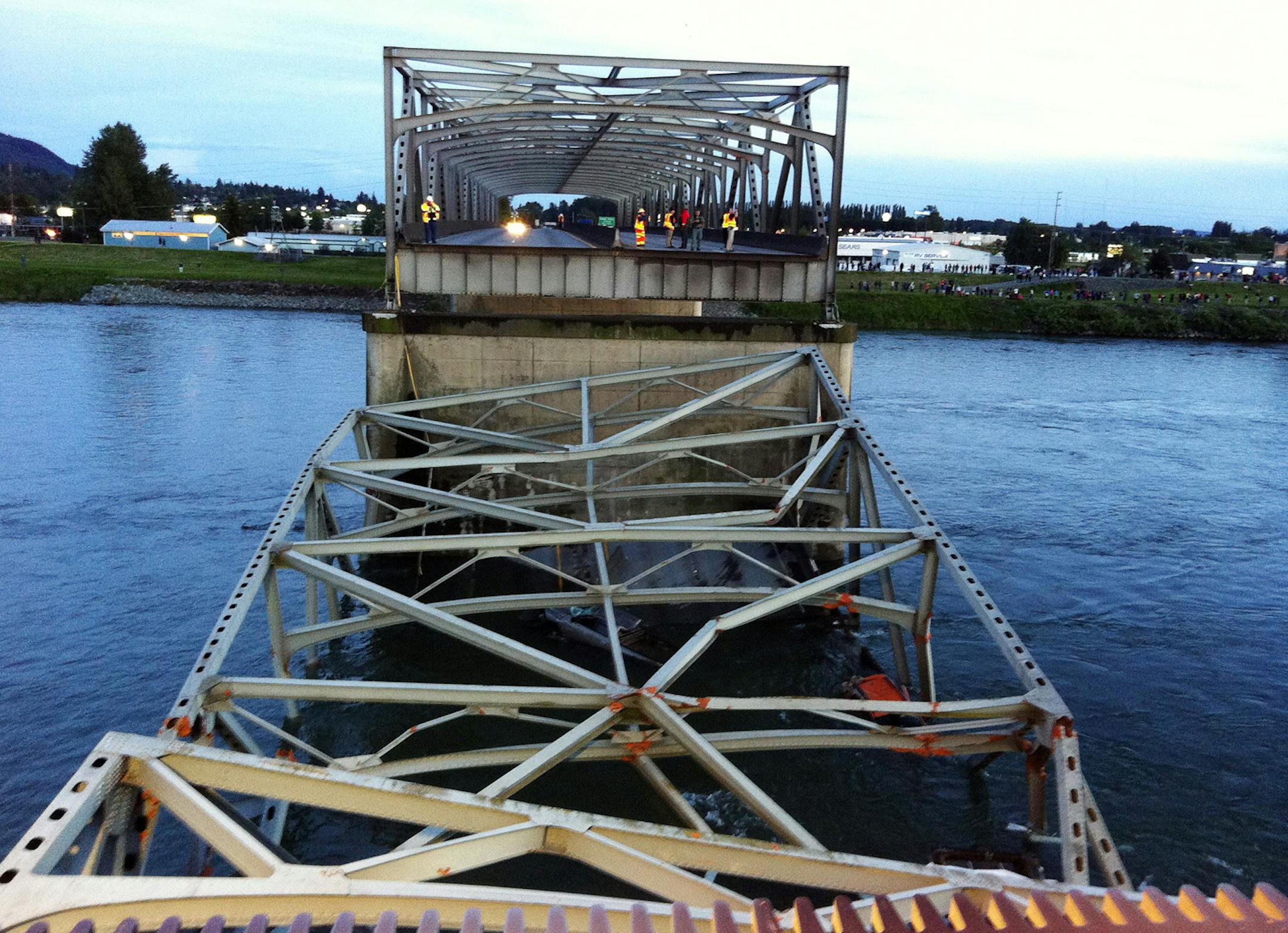 Rescue workers look over the scene after a portion of the Interstate 5 bridge collapsed into the Skagit River in Mount Vernon, Wash., Thursday, May 23, 2013.