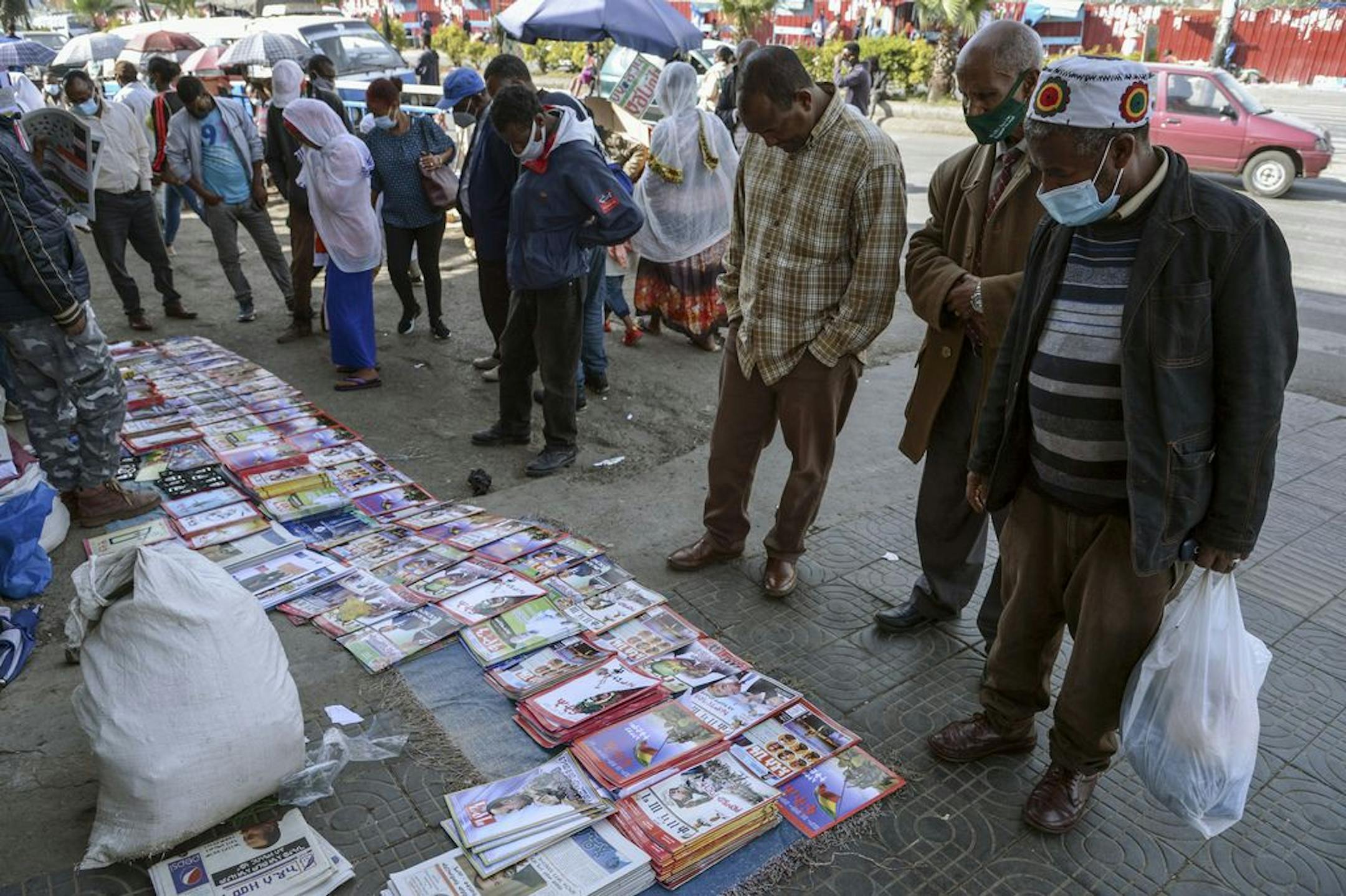 Ethiopians read newspapers and magazines reporting on the current military confrontation in the country at a news stand on a street in the capital Addis Ababa, Ethiopia Saturday, Nov. 7, 2020. Ethiopia moved Saturday to replace the leadership of the country's defiant northern Tigray region, where deadly clashes between regional and federal government forces are fueling fears the major African power is sliding into civil war.
