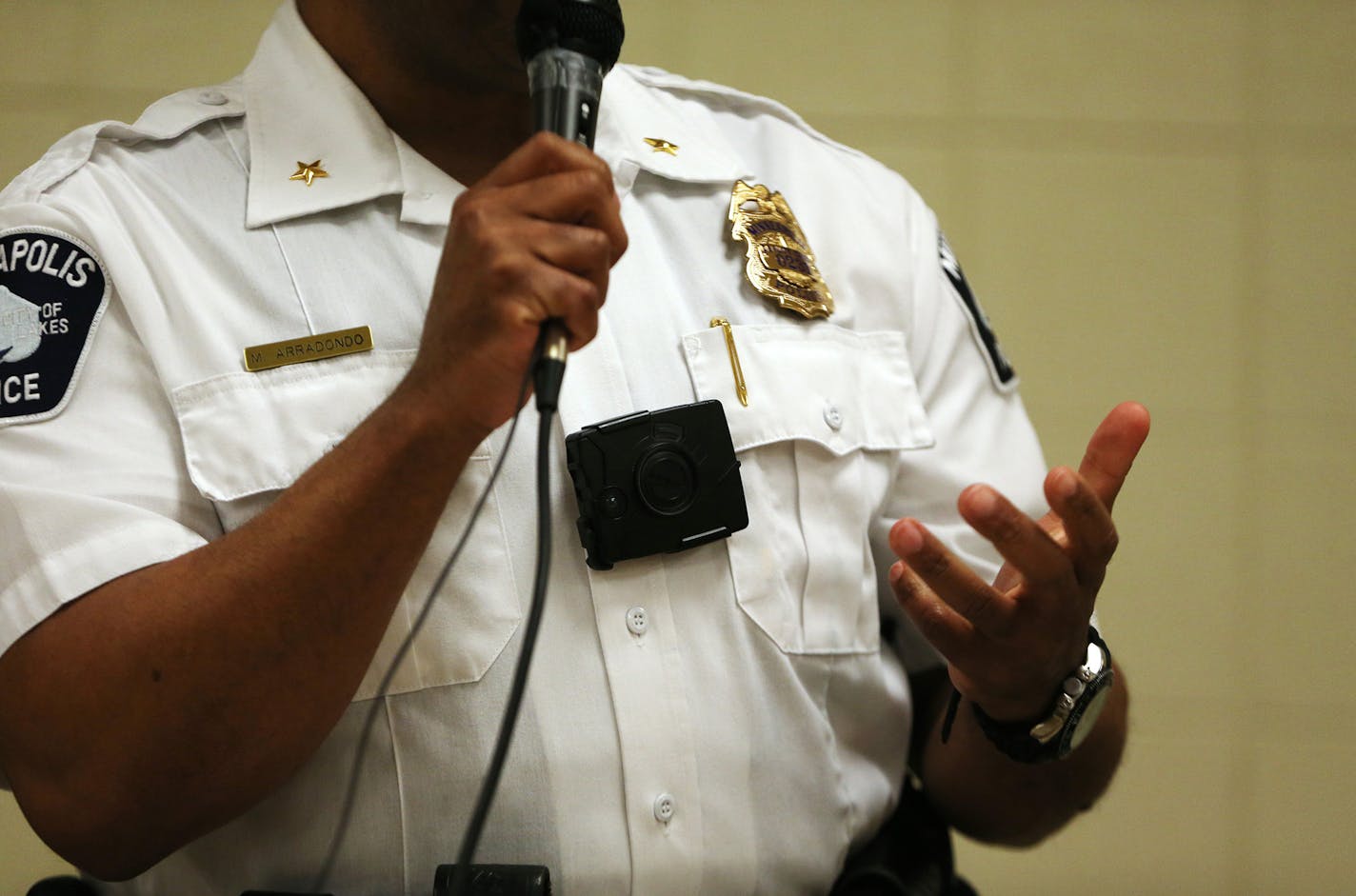 Deputy Chief Medaria Arradando demonstrates a mockup body camera similar to the ones the Minneapolis Police have ordered. ] Mark Vancleave - mark.vancleave@startribune.com * The Minneapolis Police Department took input on a draft policy for body camera use from community members at the Phillips Community Center on Thursday, March 24, 2016. ORG XMIT: MIN1603242057530730