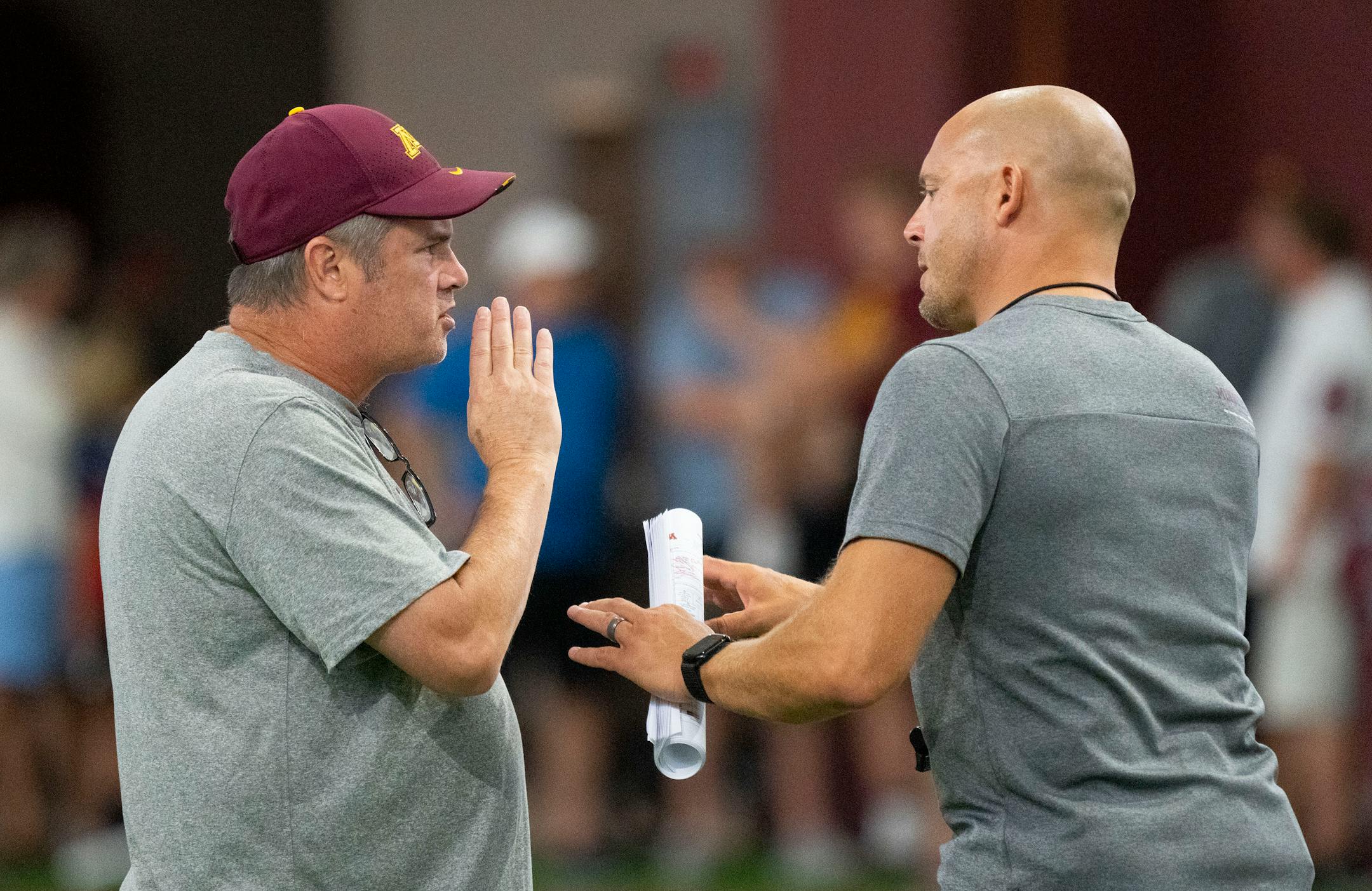 Gophers football offensive coordinator Kirk Ciarrocca speaks with head coach P.J. Fleck during the football team's open practice Saturday.