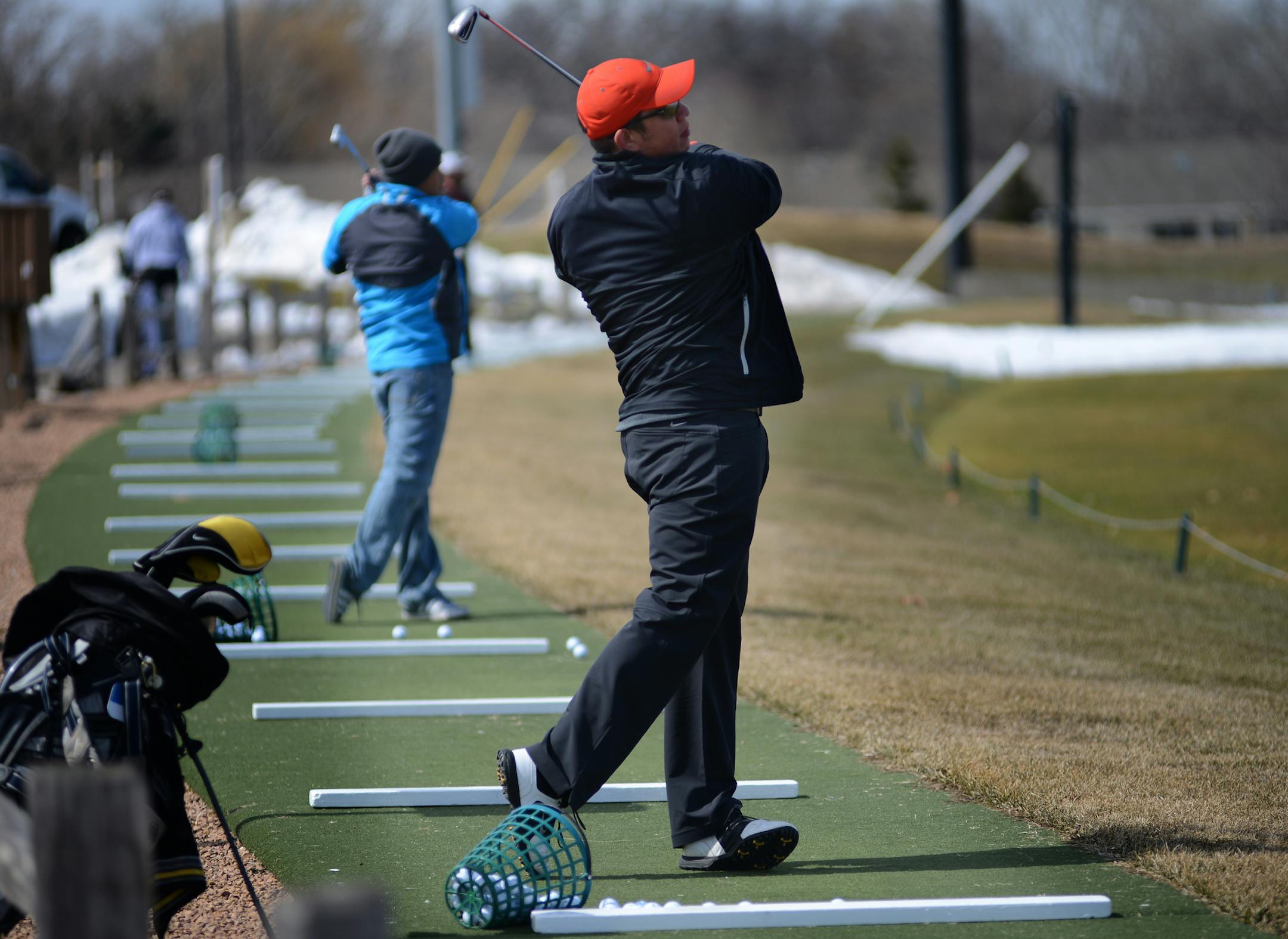 John Santiago of Maplewood hit golf balls off the mats at The Ponds at Battle Creek in Maplewood, which opened at noon on Wednesday. The snowbanks didn't bother the golfers -- in fact, it gave them something to aim for. Neither did the threat of a spring blizzard in just two days.