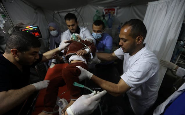 Palestinian medics carry a young wounded in the Israeli bombardment of the Gaza Strip, to the Kuwaiti Hospital in Rafah refugee camp, southern Gaza St