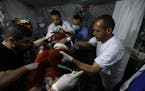 Palestinian medics carry a young wounded in the Israeli bombardment of the Gaza Strip, to the Kuwaiti Hospital in Rafah refugee camp, southern Gaza St