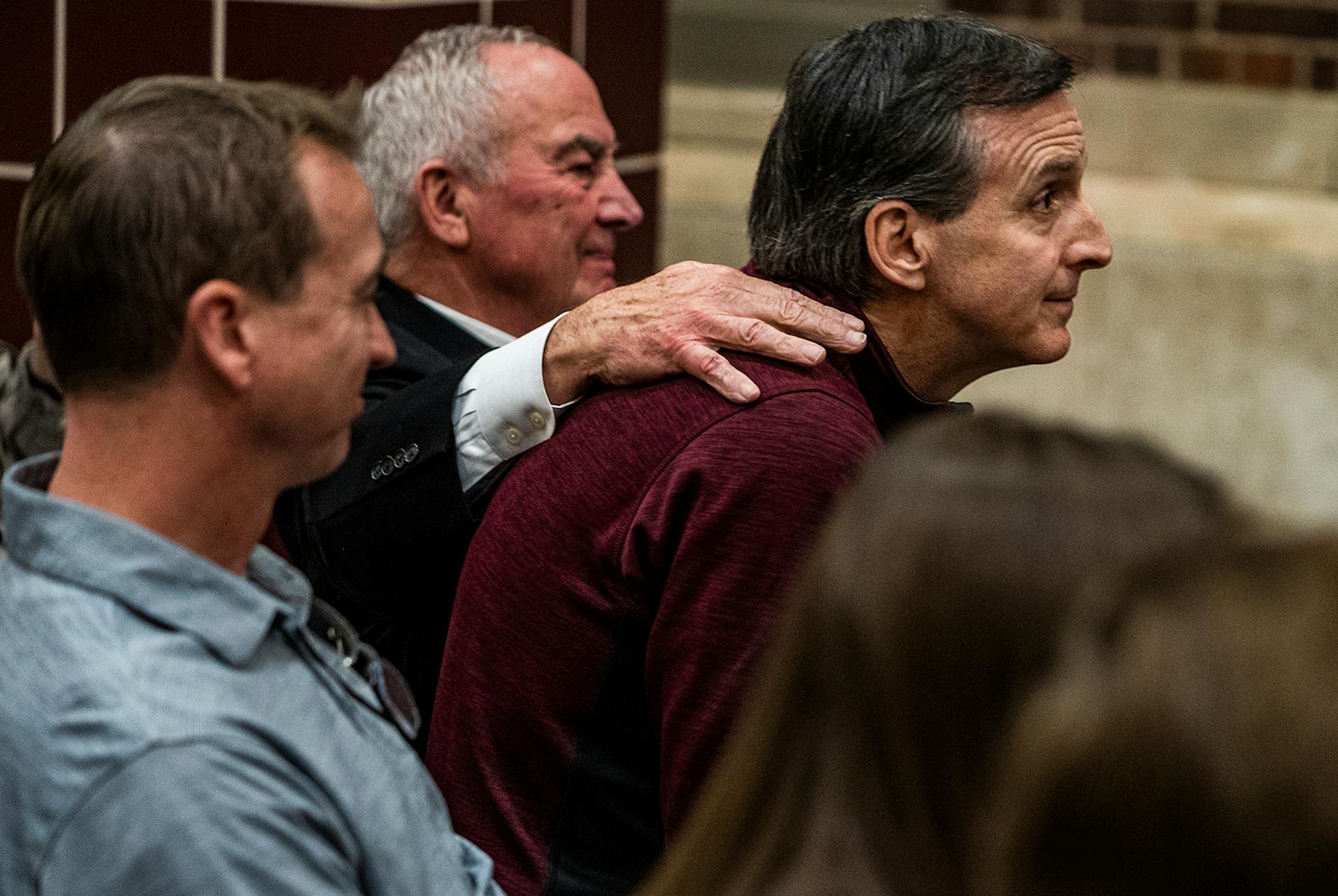 U of M Regent Dave Metzen comforted former governor Tim Pawlenty during a celebration of Gophers hockey legend Doug Woog at South St. Paul High School.
