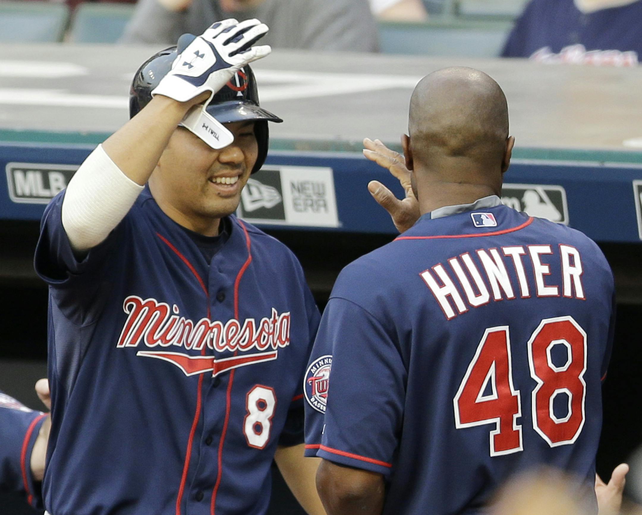 Minnesota Twins' Kurt Suzuki, left, congratulates teammate Torii Hunter after Hunter scored on an RBI-single by Joe Mauer in the first inning of a baseball game against the Cleveland Indians, Friday, May 8, 2015, in Cleveland. (AP Photo/Tony Dejak)