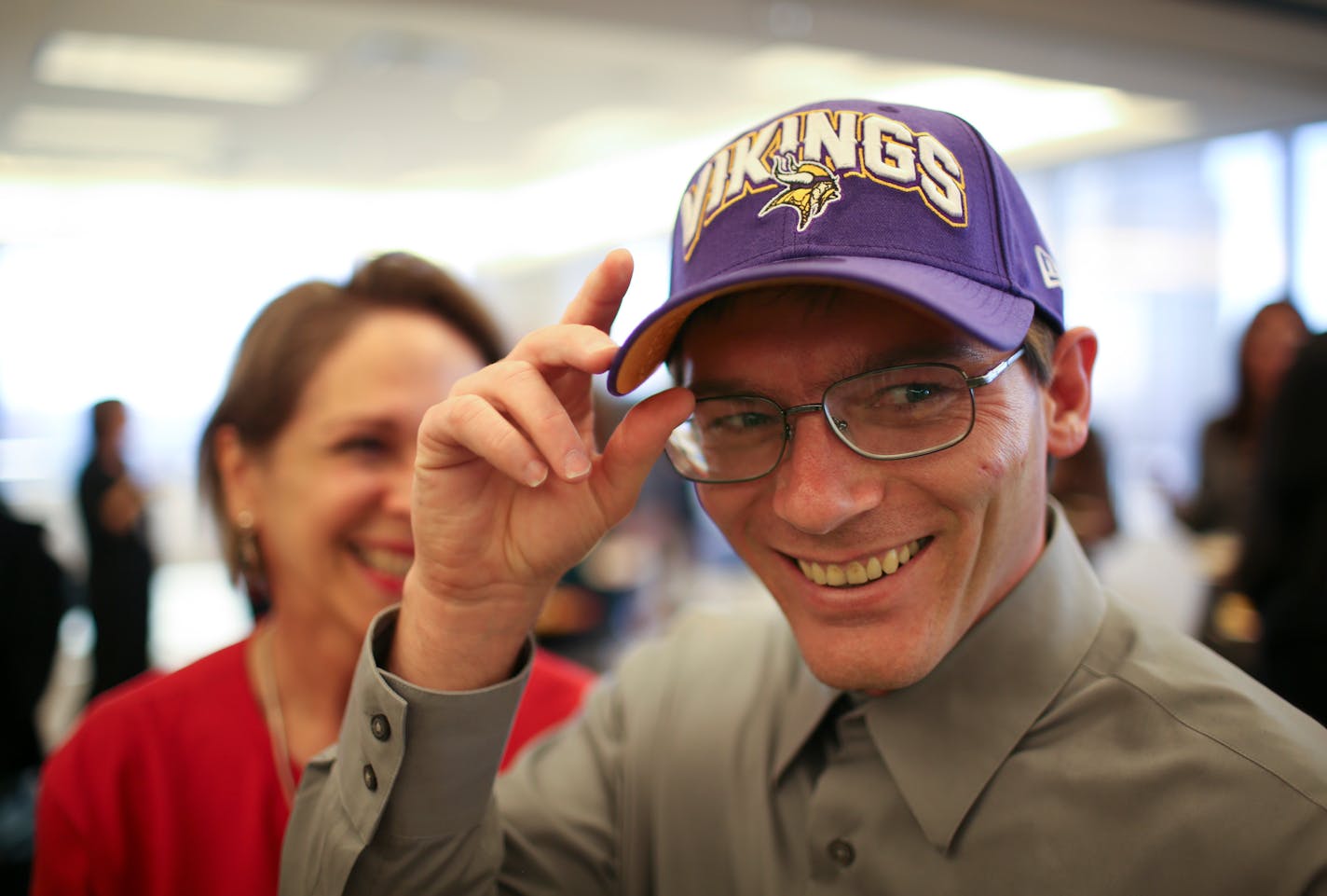 Damon Thibodeaux received a Vikings cap during a reception at Fredrikson & Byron to welcome him to Minneapolis.