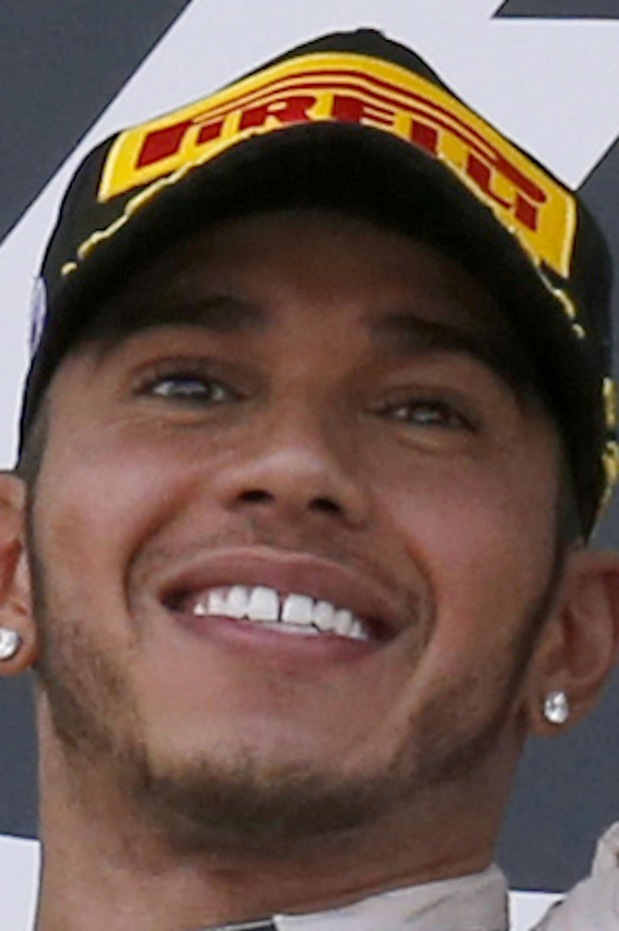 Mercedes driver Lewis Hamilton of Britain holds up the trophy on the podium after winning the Japanese Formula One Grand Prix at the Suzuka Circuit in Suzuka, central Japan, Sunday, Sept. 27, 2015. (AP Photo/Toru Takahashi)