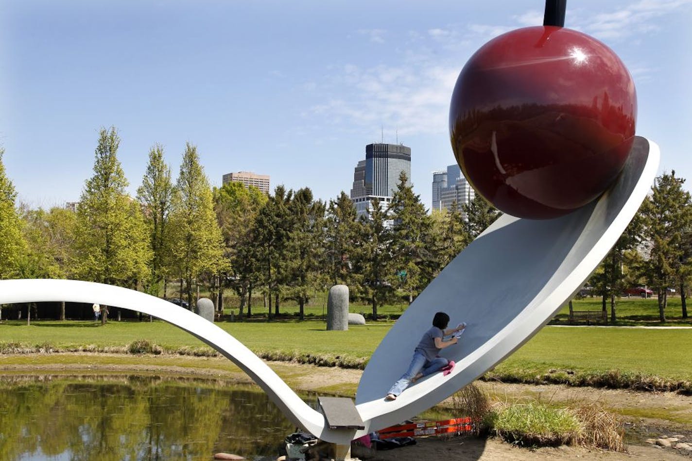 Donna Haberman of the Midwest Art Conservation Center in Minneapolis removed graffiti from "Spoonbridge and Cherry" in the Walker Sculpture Garden on Monday. The Claes Oldenburg work was brought back to presentable condition.