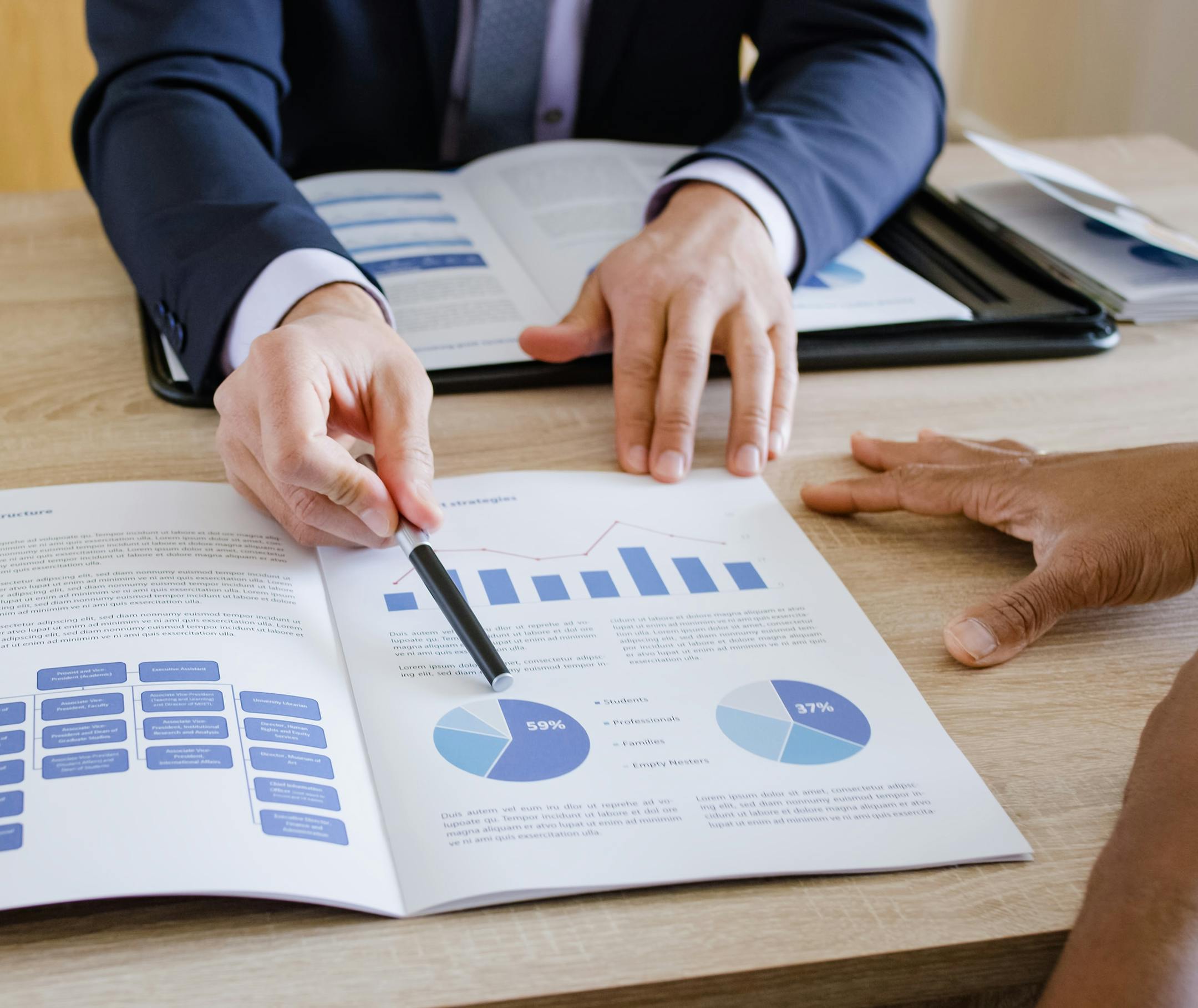 Banker explaining pie chart to couple at home.