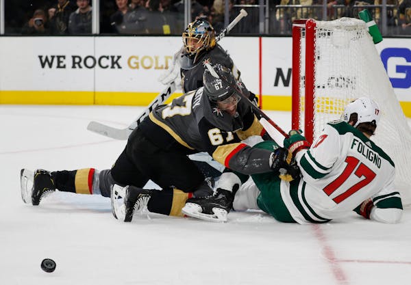 Vegas left wing Max Pacioretty (67) and Wild left wing Marcus Foligno (17) fall to the ice while battling for the puck during the third period