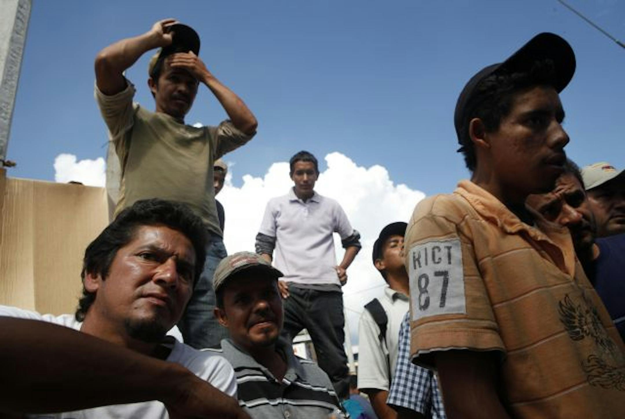 File photo: A group of deportees wait to try out shoes donated by a humanitarian near the U.S.-Mexico border.