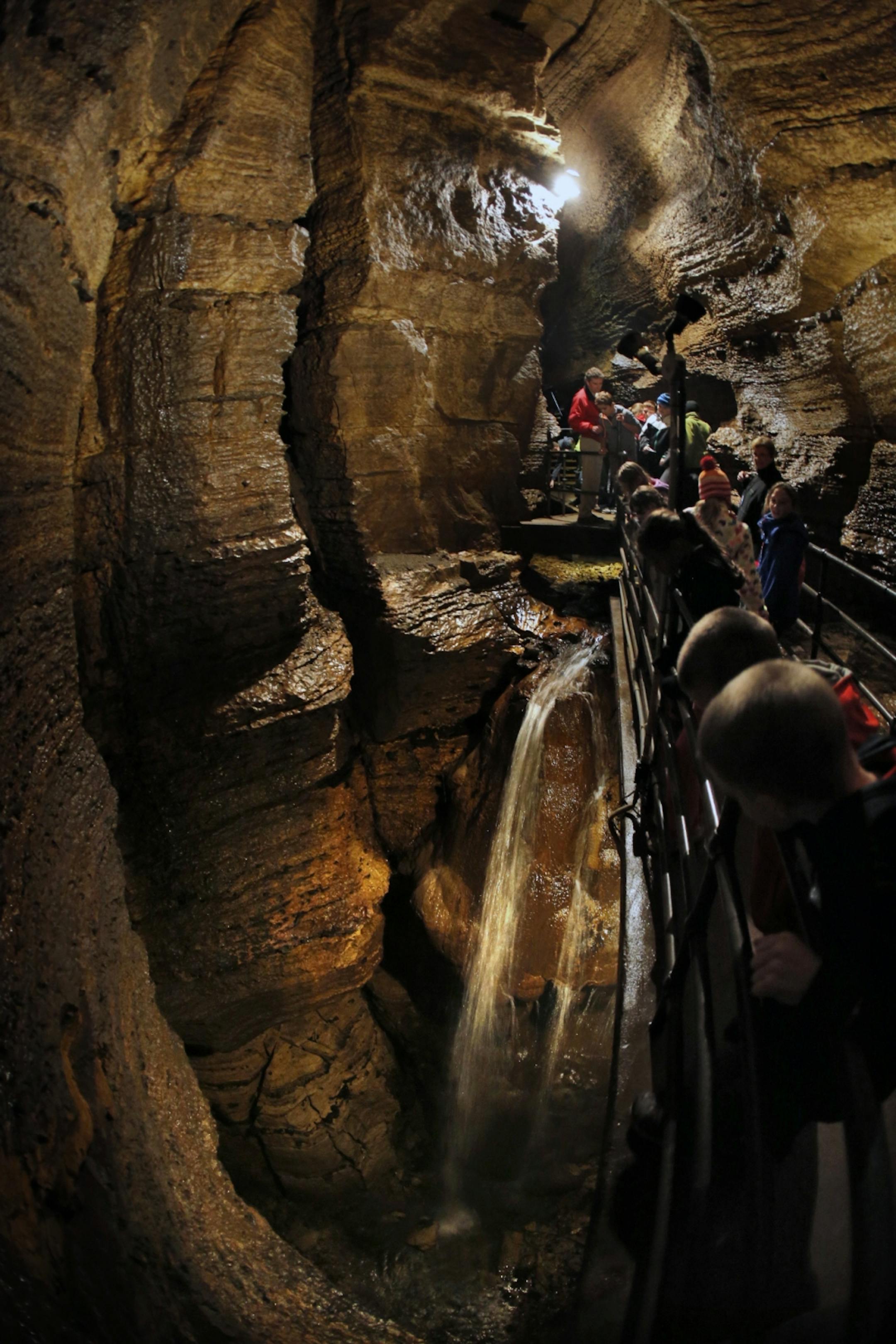 A class of school children explores the depths of Niagra Cave south of Harmony, including this 60 foot waterfall below the far