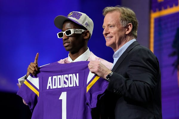 USC wide receiver Jordan Addison, left, and Roger Goodell, NFL Commissioner, hold a team jersey after Addison was chosen by the Minnesota Vikings.