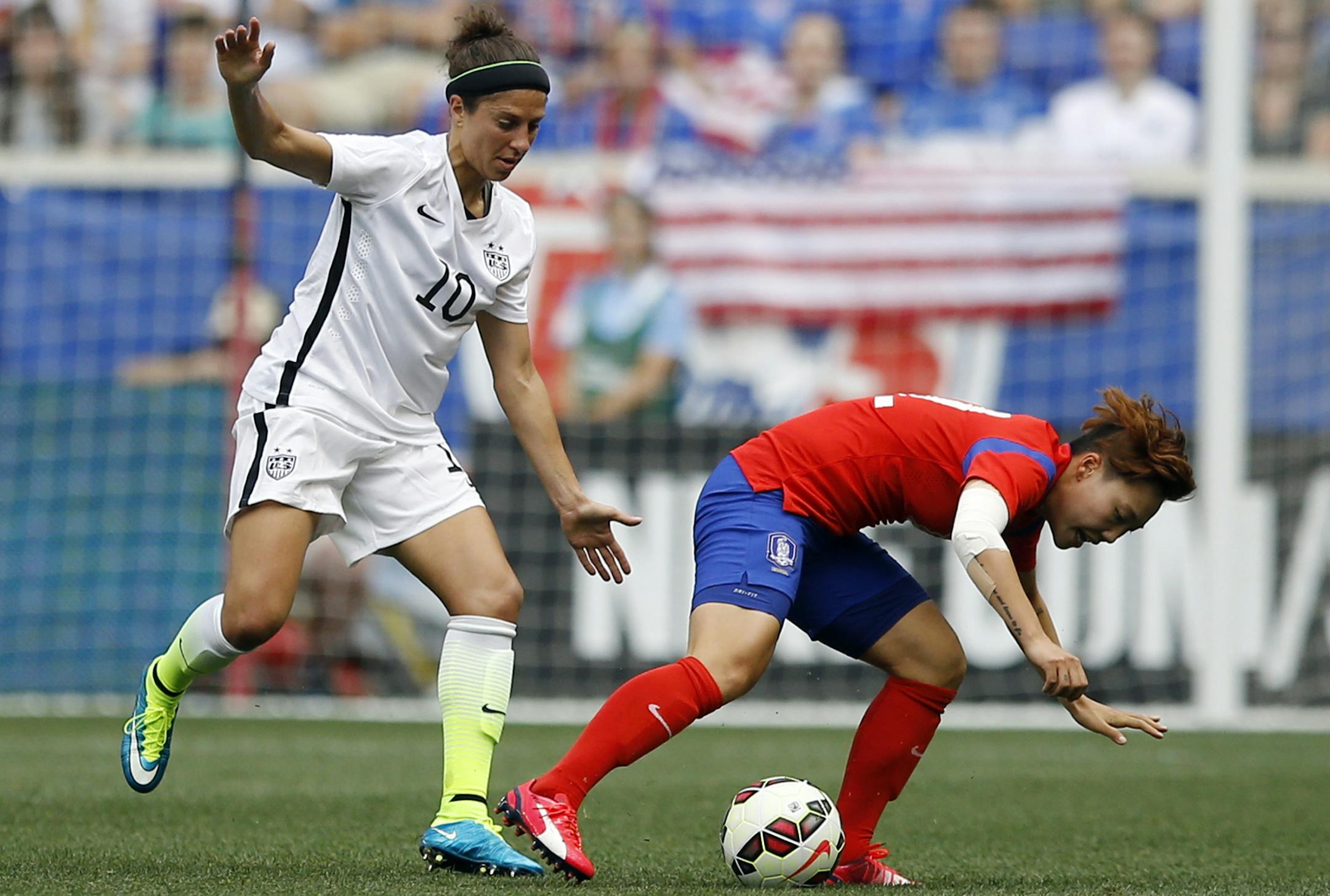 FILE - In this May 30, 2015, file photo, United States midfielder Carli Lloyd, left, battles for the ball with South Korea forward Jung Seolbin during the first half of an international friendly soccer match in Harrison, N.J. In broadcasting the Women's World Cup, Fox executives are thrilled for the chance to potentially see the favored U.S. team make a run to the title. But what can really draw in viewers is the realization that the Americans could lose. (AP Photo/Julio Cortez, File)