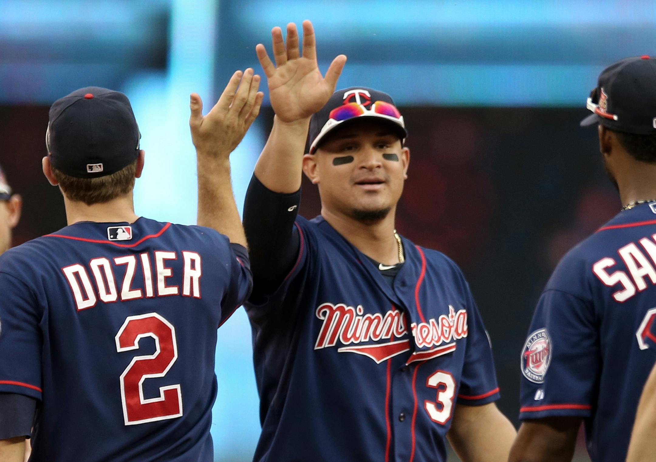 Minnesota Twins right fielder Oswaldo Arcia, center, celebrates with teammates after the Twins beat the Cleveland Indians 4-1 in a baseball game, Thursday, Aug. 21, 2014, in Minneapolis. (AP Photo/Jim Mone)