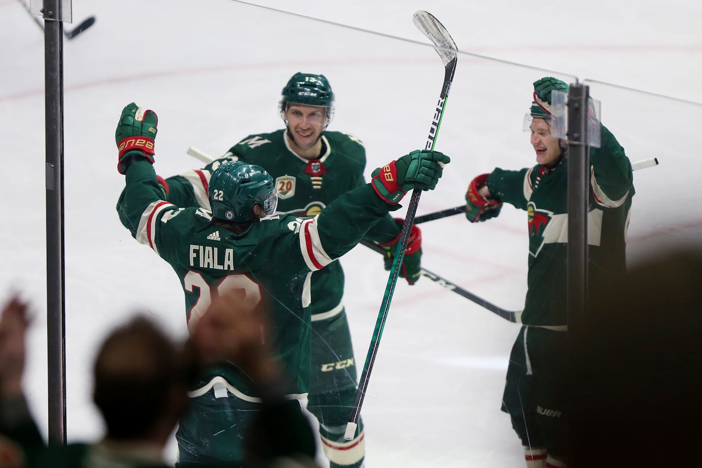 The Wild's Kevin Fiala raises his arms next to Nick Bonino (13) and Kirill Kaprizov (97) after his third goal Wednesday.