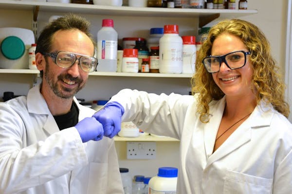In this undated photo provided by Prifysgol Aberystwyth University researchers David Whitworth, left, and Sara Mela, pose for photo in the lab at Prif