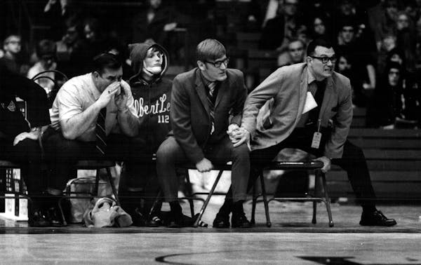 March 28, 1971 Albert Lea coach Paul Ehrhard (right) grasps an assistant's knee in a tense moment. Minneapolis Sunday Tribune