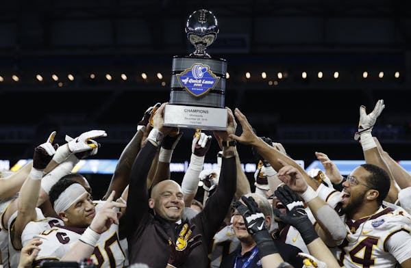 Minnesota head coach P.J. Fleck holds the champions trophy after the Quick Lane Bowl NCAA college football game against Georgia Tech, Wednesday, Dec. 