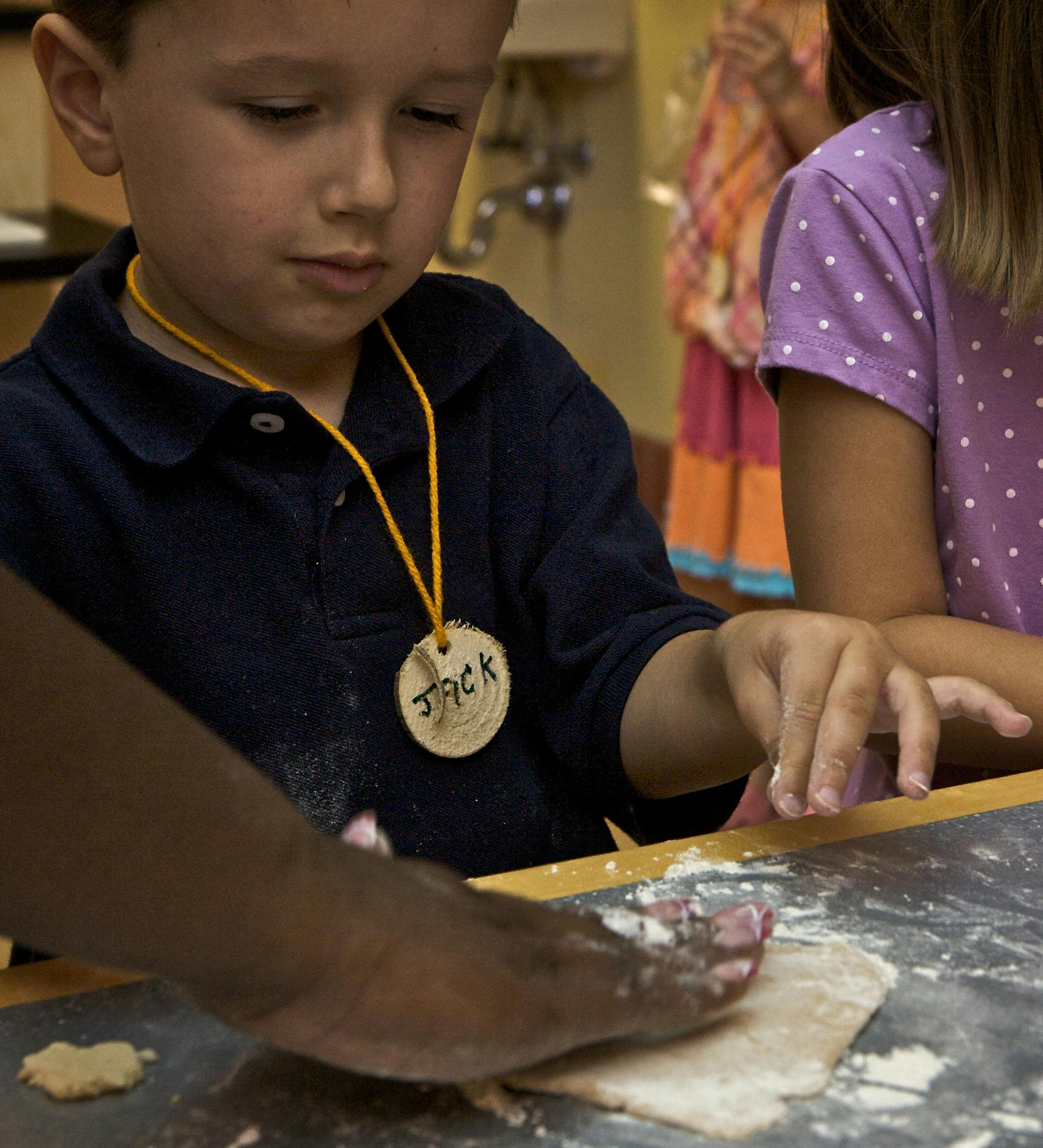 Jack Hering, 5, from Buffalo gets help from Ebony Turner, a teacher at the Landscape Arboretum.