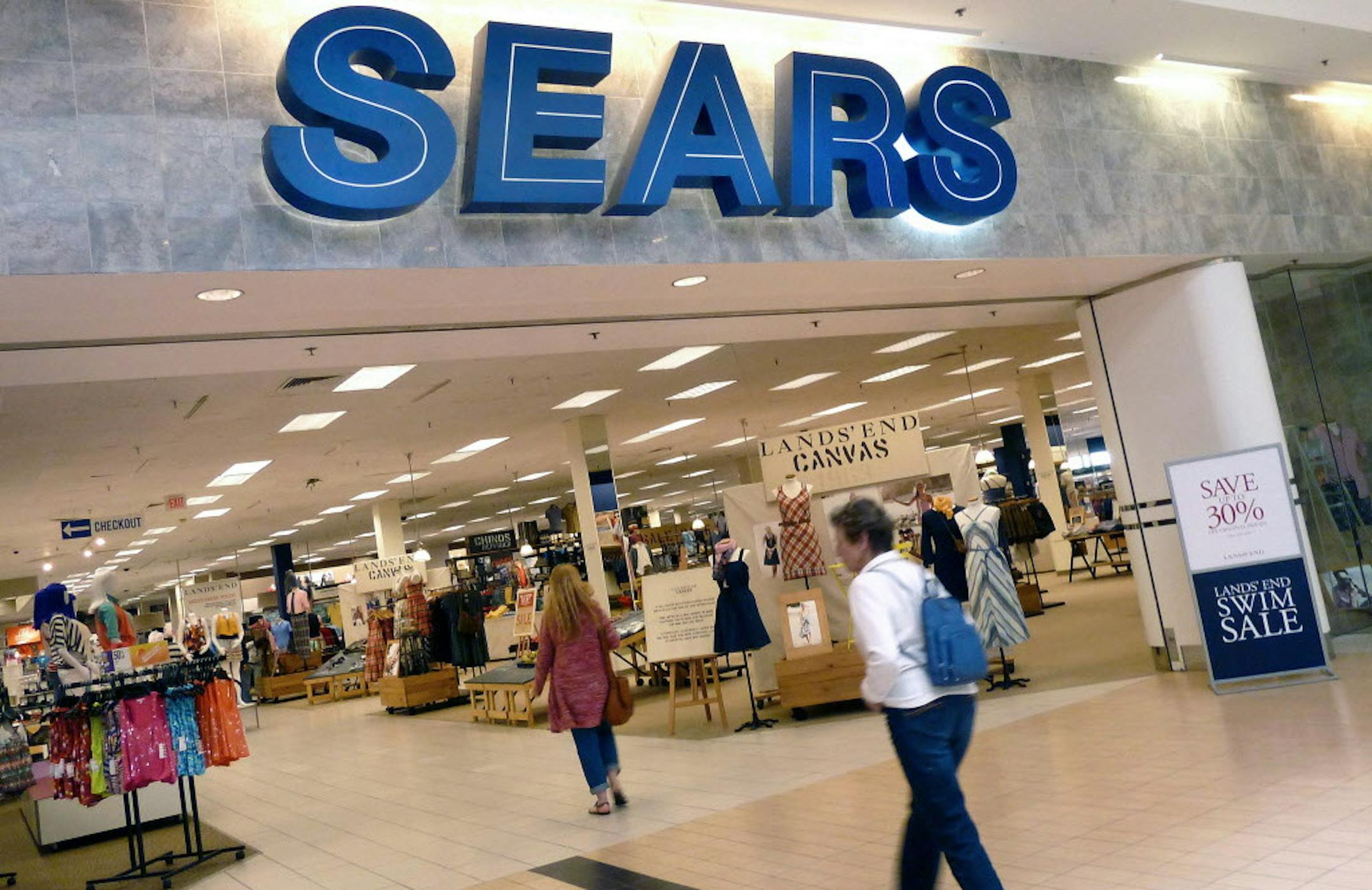 FILE - In this Thursday, May 17, 2012, file photo, shoppers walk into Sears in Peabody, Mass. Sears' announced Thursday, May 26, 2016, its fiscal first-quarter loss widened as it suffered another sales drop at its Kmart and namesake stores. The retailer also announced that it's looking at options for its prized Kenmore, Craftsman and DieHard and Sears Home Services businesses, including possible partnerships or deals that could expand distribution of its brands and service offerings. (AP Photo/E