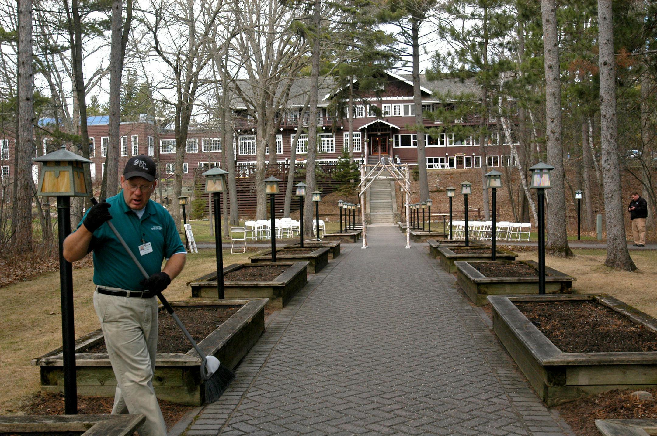 Jim Kostreba, Grand View employee, works on spring cleaning around Grand View Resort, in this view looking back from Gull Lake at the historic lodge. A wedding was going to take place later that afternoon, May 3.
