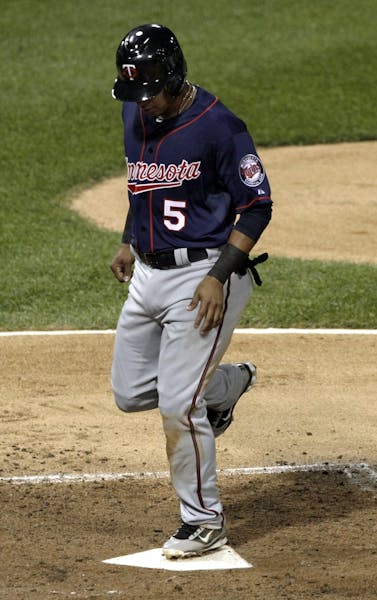Minnesota Twins' Eduardo Escobar scores on a single by Jamey Carroll during the second inning of a baseball game, Tuesday, Sept. 4, 2012, in Chicago.