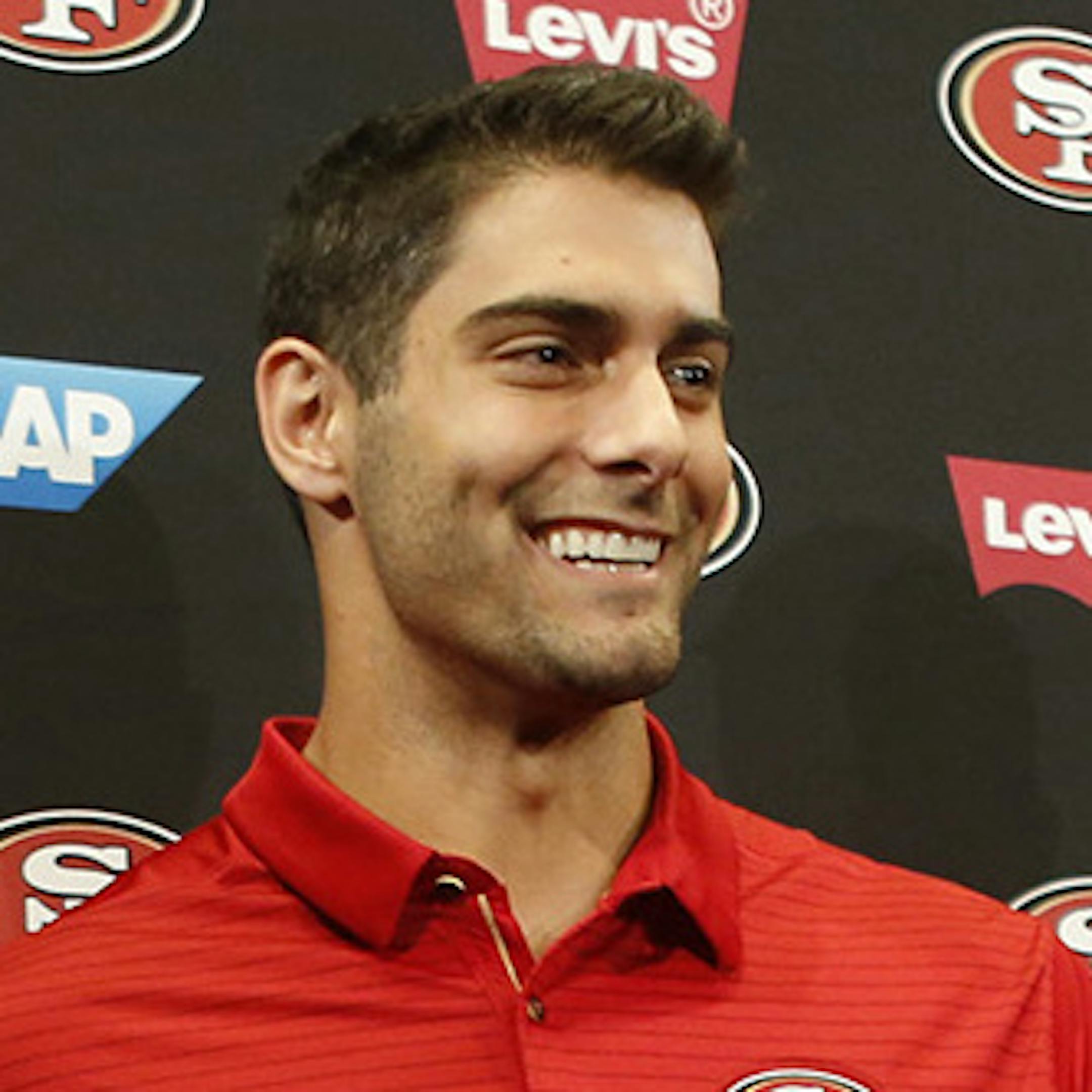 San Francisco 49ers quarterback Jimmy Garoppolo holds his new jersey as he poses for a photo with, from left, 49ers general manager John Lynch, owner Jed York and head coach Kyle Shanahan in the Levi's Stadium auditorium in Santa Clara, Calif., on Tuesday, Oct. 31, 2017. (Patrick Tehan/Bay Area News Group/TNS) ORG XMIT: 1557139 ORG XMIT: MIN2001291908343124