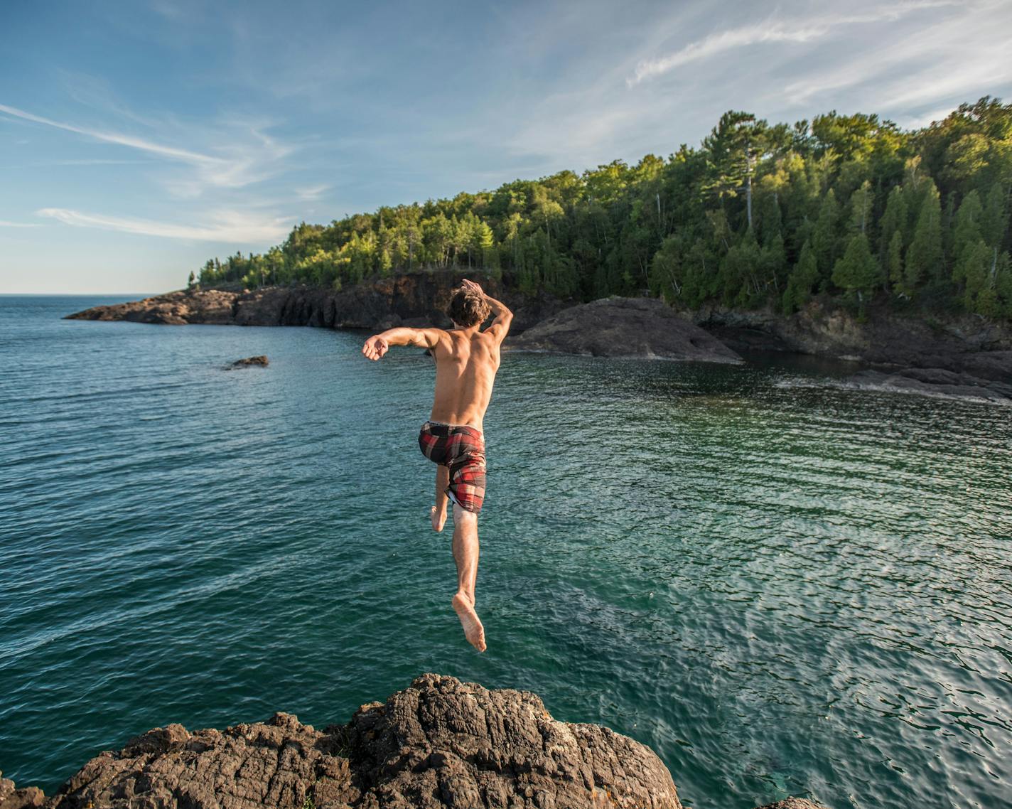 Summer activity at the Black Rocks of Presque Isle Park in Marquette, Michigan. The dark geological feature is a popular place for jumping into Lake Superior.