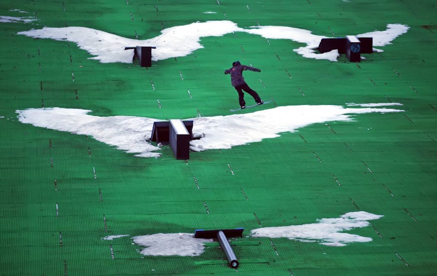 Hard core snowboarder Nick Lundquist of Minneapolis took to the slopes in the rain Wednesday evening at Buck Hill in Burnsville, trying out the "Neveplast" artificial ski surface mixed with a little snow. It's been a slow start to the ski season but Buck Hill is making it work.