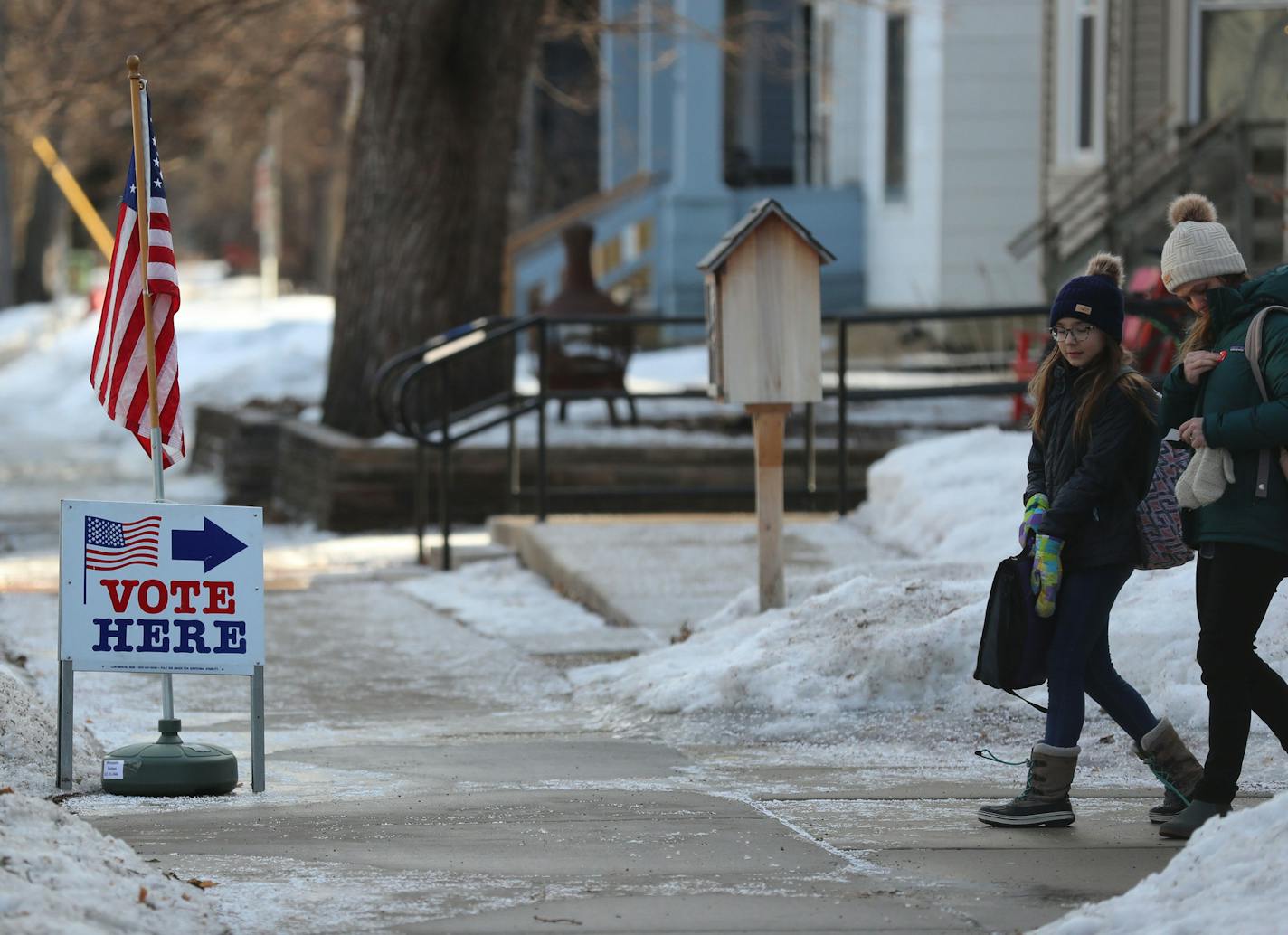 Voter Rebekah Martin places her "I voted," sticker on her jacket after casting her ballot at her polling place at First Congregation Church in Minneapolis with her daughter Adelaide, 11, in March.