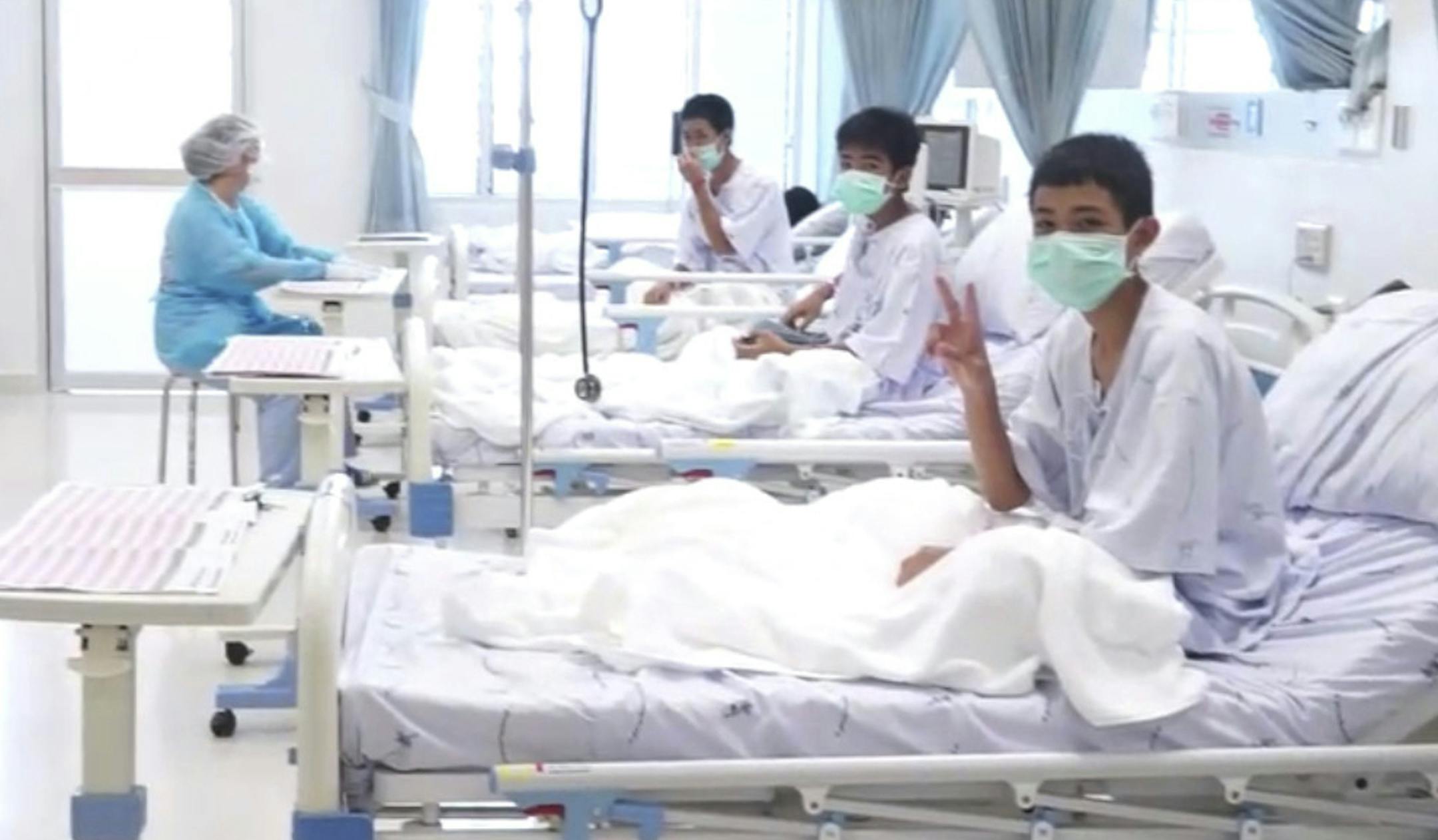In this image made from video, released by the Thailand Government Spokesman Bureau, three of the 12 boys are seen recovering in their hospital beds after being rescued along with their coach from a flooded cave in Mae Sai, Chiang Rai province, northern Thailand. (Thailand Government Spokesman Bureau via AP)