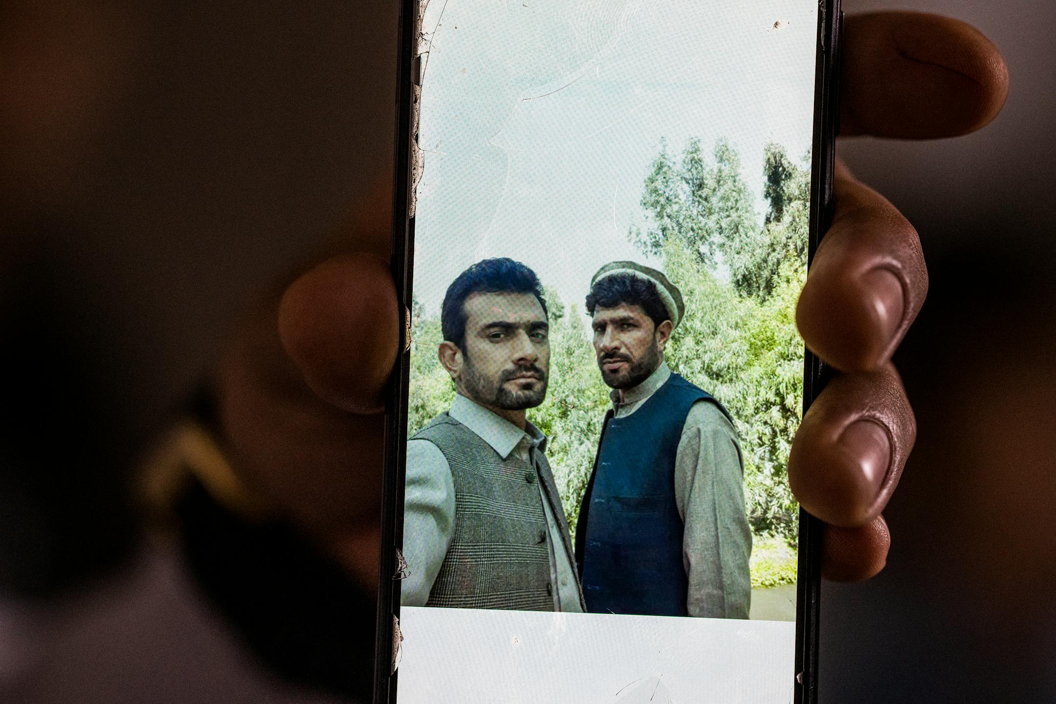 Sher Mulakhail shows a picture of himself, right, and his 'brother' Mirwais Momand from their days in Afghanistan in Bloomington.