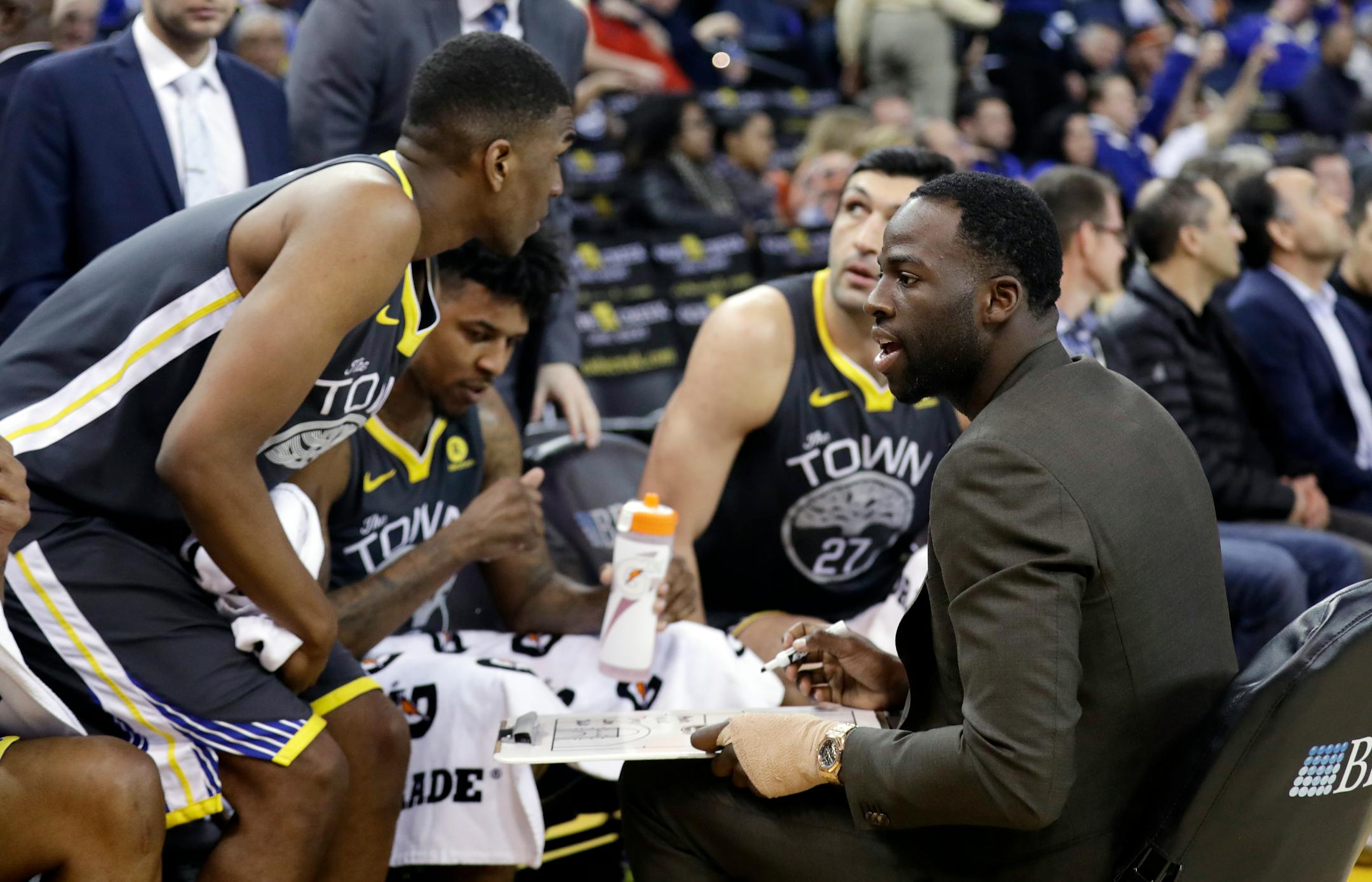 Golden State Warriors' Draymond Green, right, calls a play from the bench during the second half of Monday's game.
