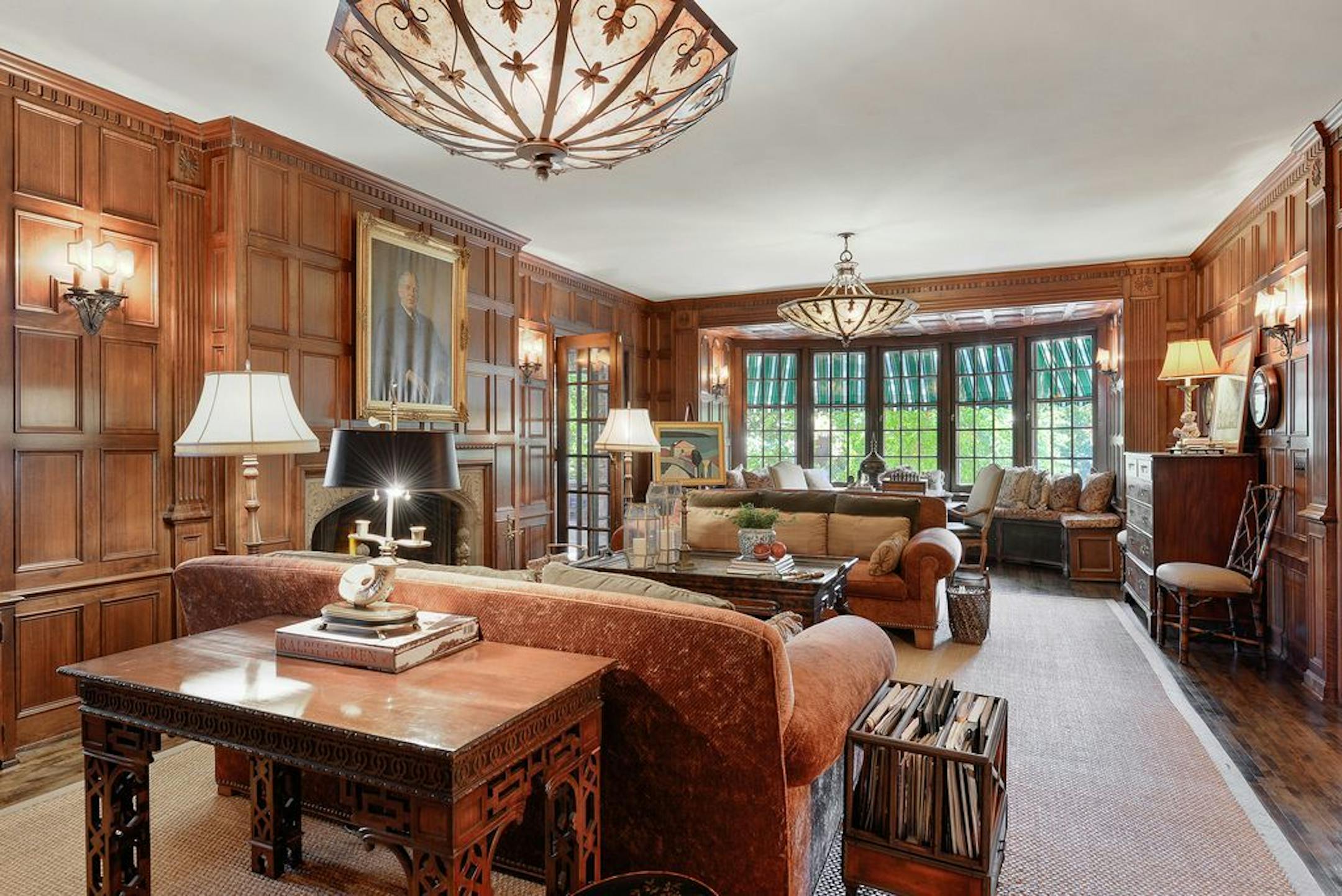 The wood-paneled room has a fireplace, one of six in the home.
