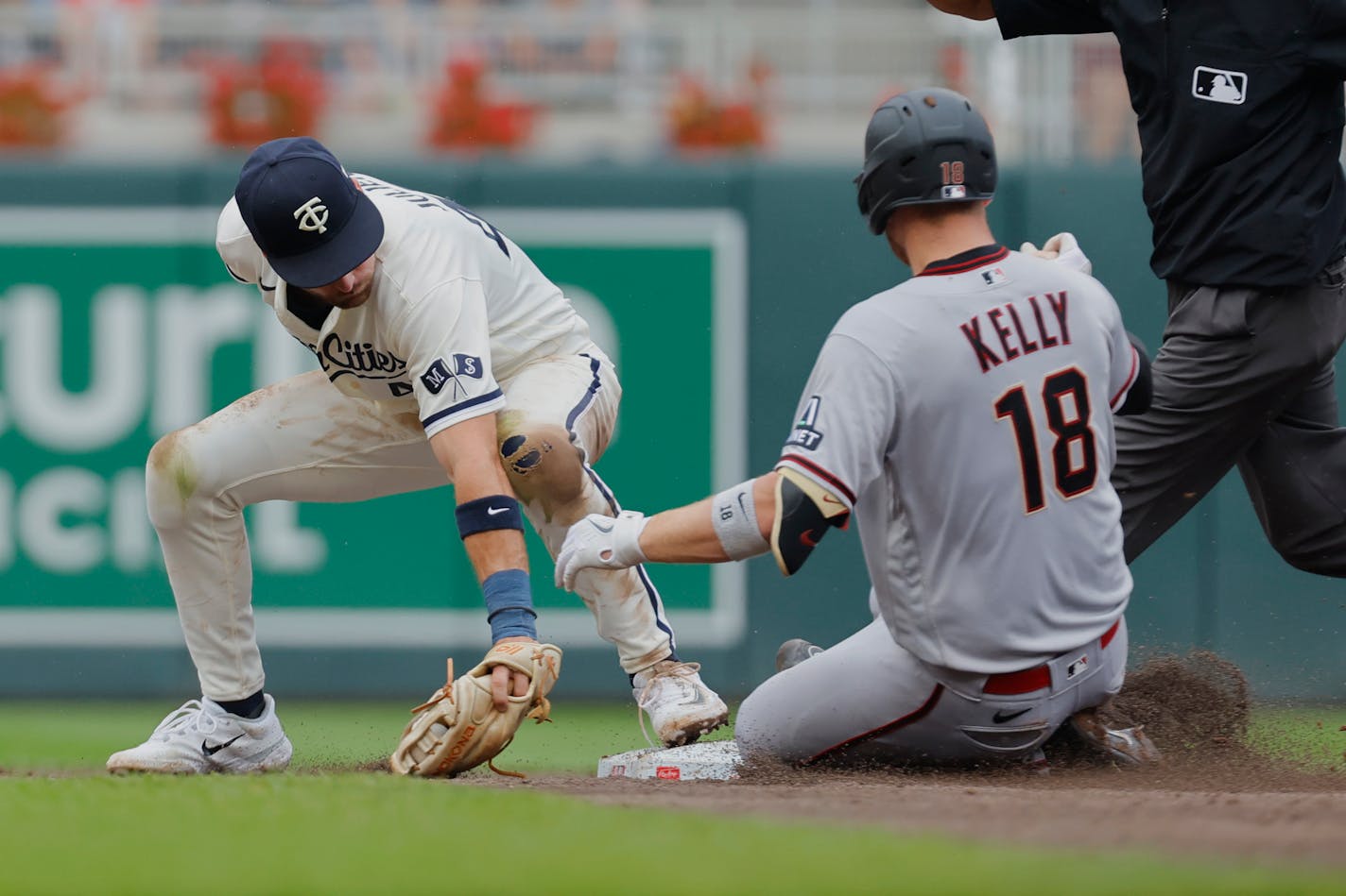 Arizona Diamondbacks' Carson Kelly (18) slides into second base for a double ahead of a tag by Minnesota Twins shortstop Carlos Correa, left, in the third inning of a baseball game Sunday, Aug. 6, 2023, in Minneapolis. (AP Photo/Bruce Kluckhohn)